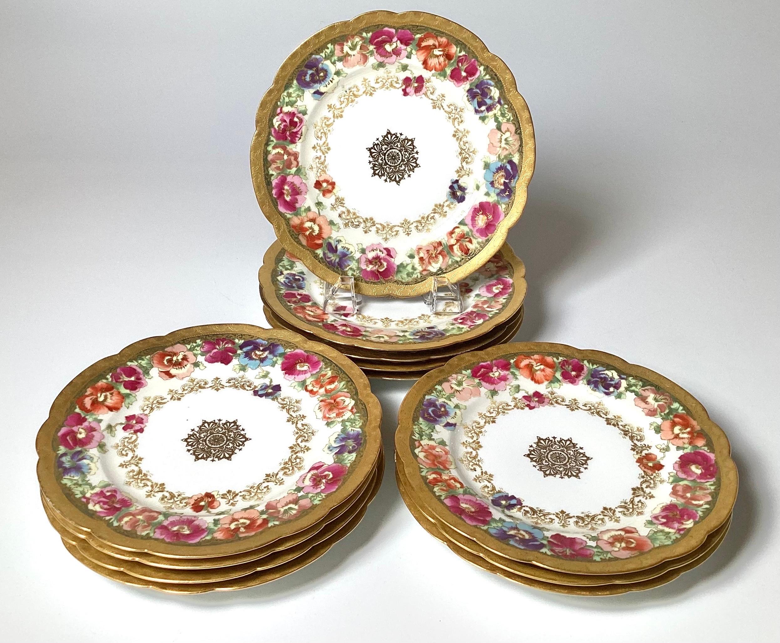 Ein Satz von 12 handgemalten floralen und vergoldeten Tellern mit eleganten Bordüren und einem Medaillon in der Mitte, spätes 19. Jahrhundert, auf den Rückseiten mit Haviland Limoges France gekennzeichnet. In Kombination mit einem größeren Teller