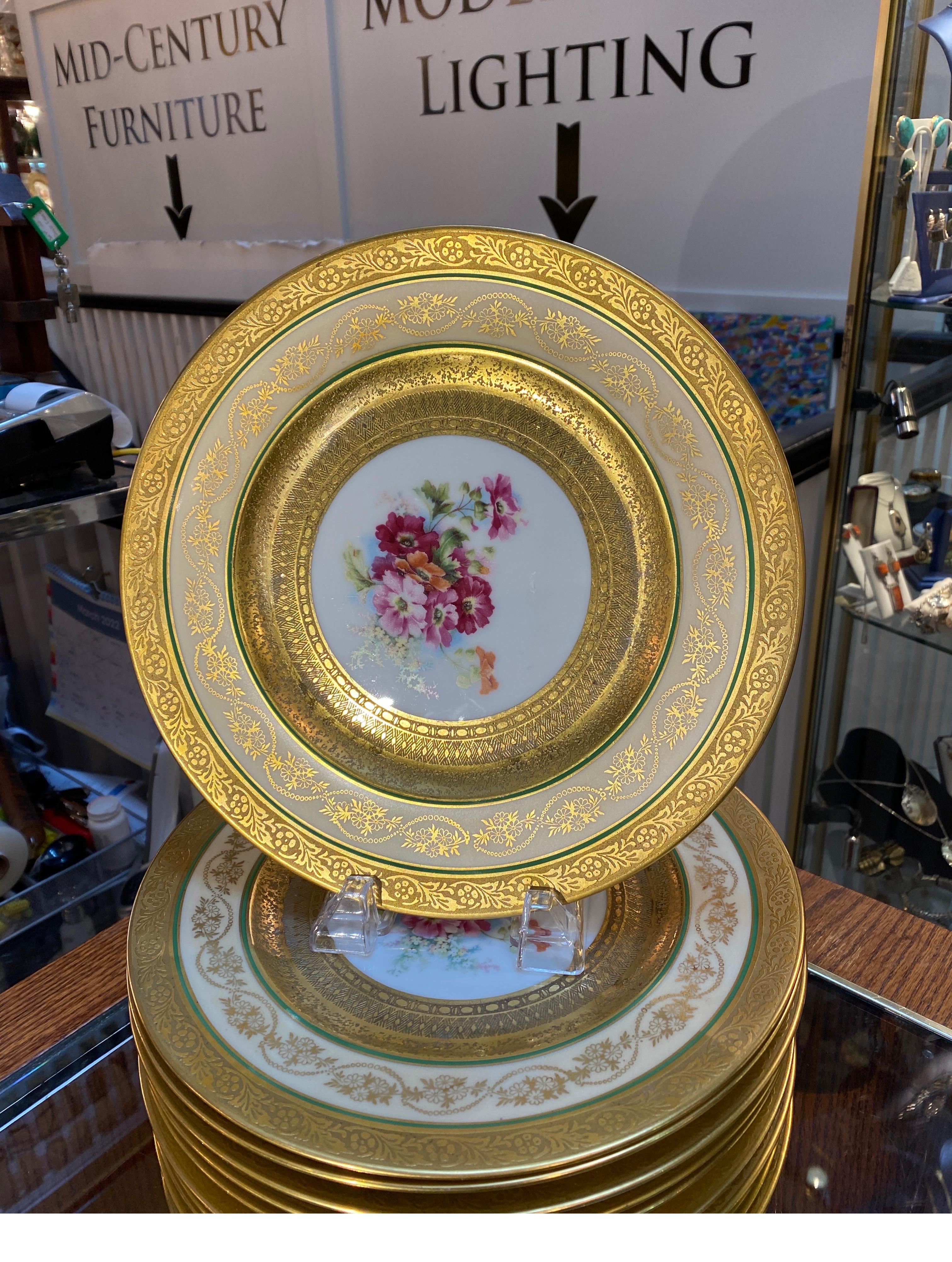 An elegant set of heavy gold bordered Hutschenreuther floral service plates. The set with gold bands with a thin sage band surrounding a graceful floral center.  Stunning cabinet pieces or regal table setting 