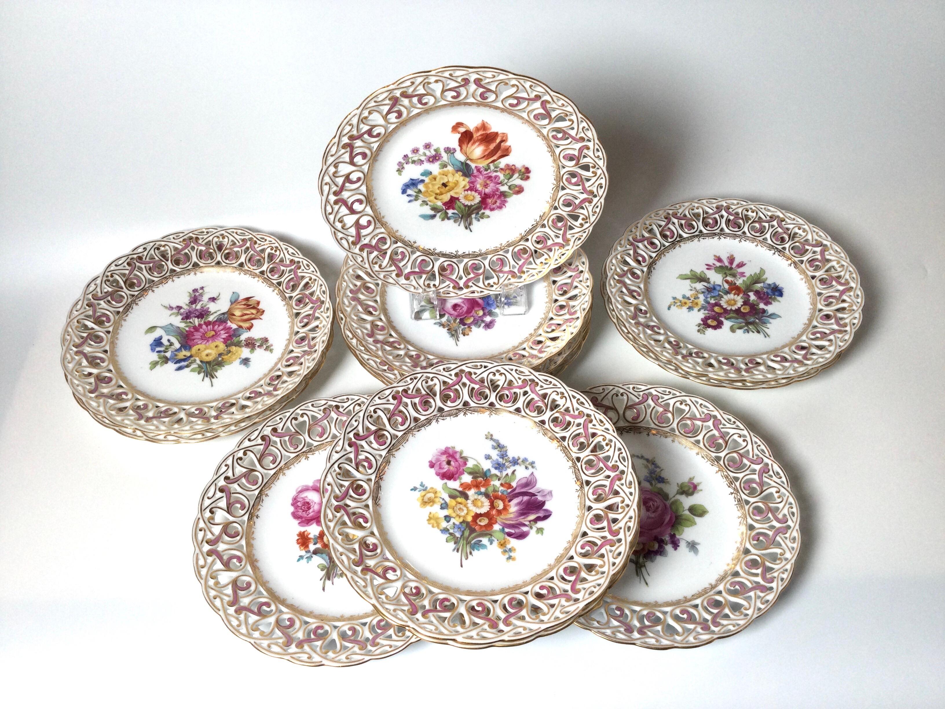 A set of 12 reticulated service paltes by Dresden, circa 1900. The beautifully painted centers of floral bouquets with hand painted and hand gilt details along the pierced borders. 9.5 inches in Diameter.