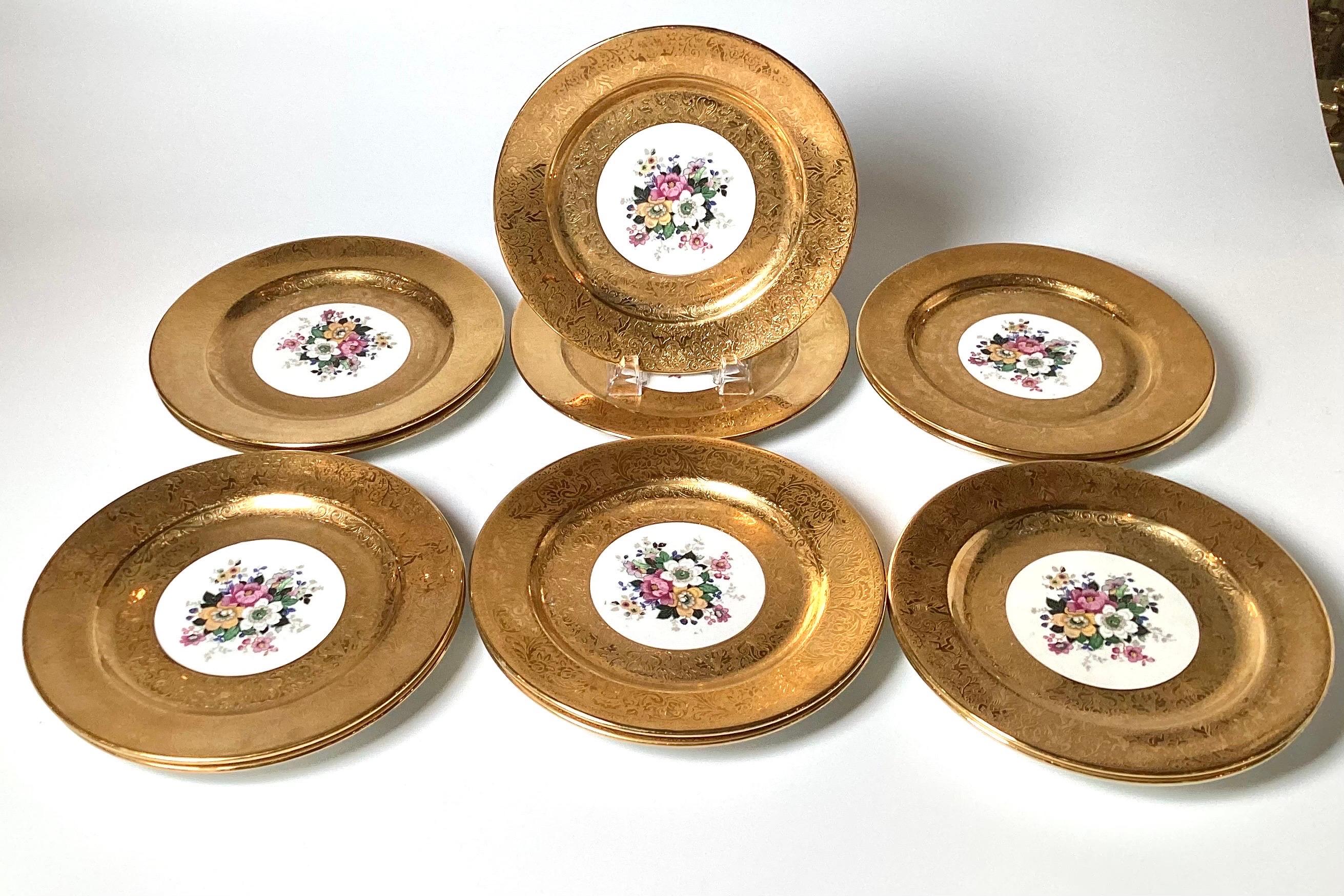 A set of 12 elaborated gold and floral service plates.  The plates with a broad 22 k gold border with a bouquet of Dresden floral centers.  The plates make for an elegant table or a stunning display in a cabinet.  10.25 inches in diameter