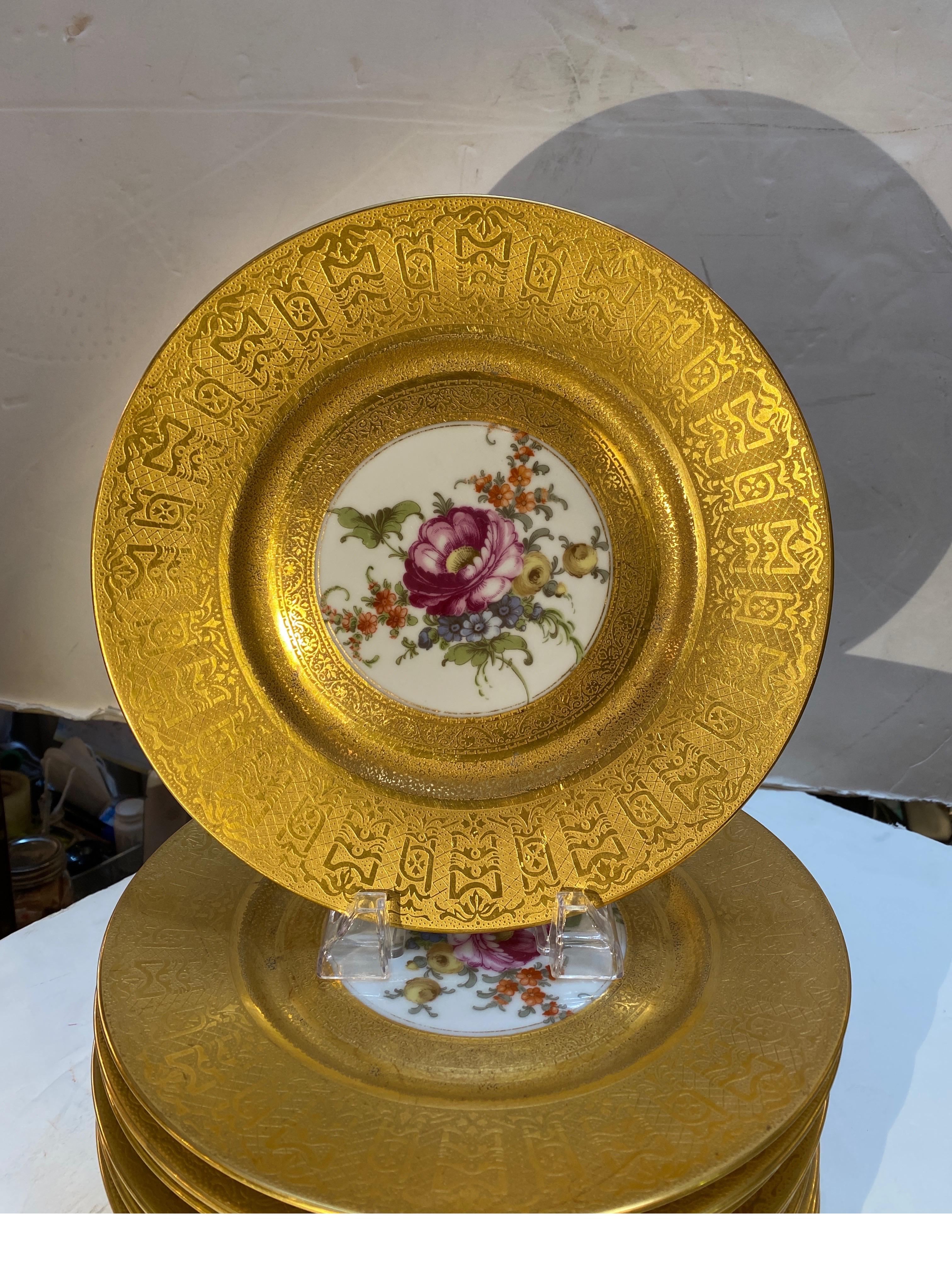 A set of lavish heavy gilt floral service plates by Heinrich and Company, Bavaria. The 10.5 diameter plates with thick textured borders against white porcelain with Dresden floral centers.