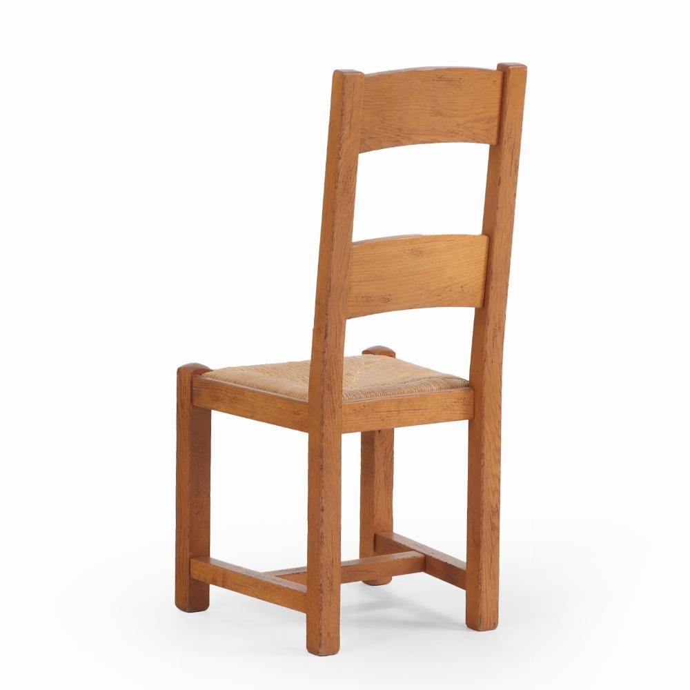 Ha stecche superiori con decorazioni in grano intagliato, sedili in giunco e gambe quadrate unite da barelle H.