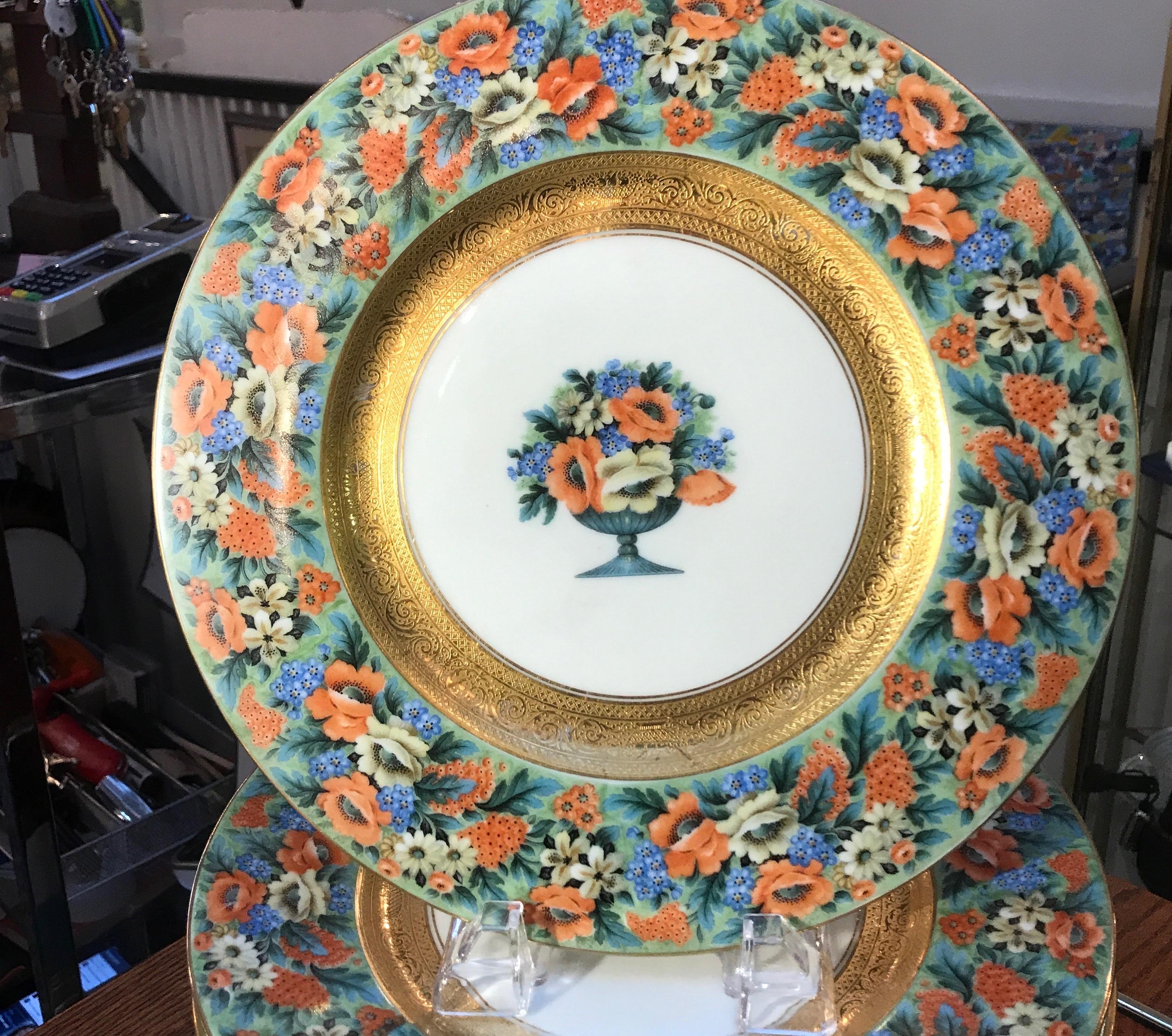 A beautiful set of broad floral band service plates with gilt decoration. The elaborate floral borders with central urn and floral medallion in German porcelain, circa 1930. By Black Knight, Hutchenreuther 