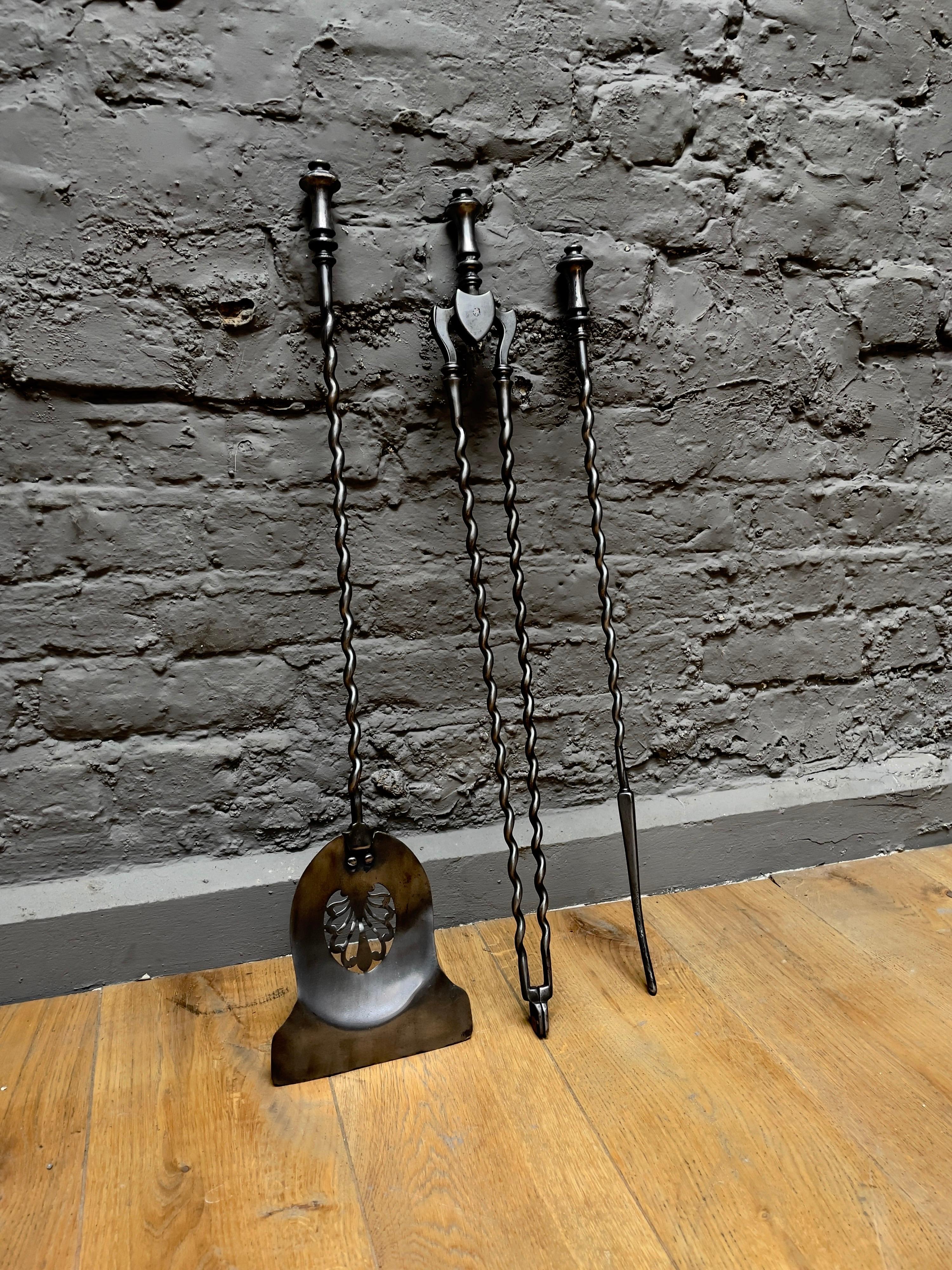 A good quality set of antique English fire tools, in burnished/polished steel with finial handles, barley twist design shafts and pierced shovel. 

Sizes given of largest piece.