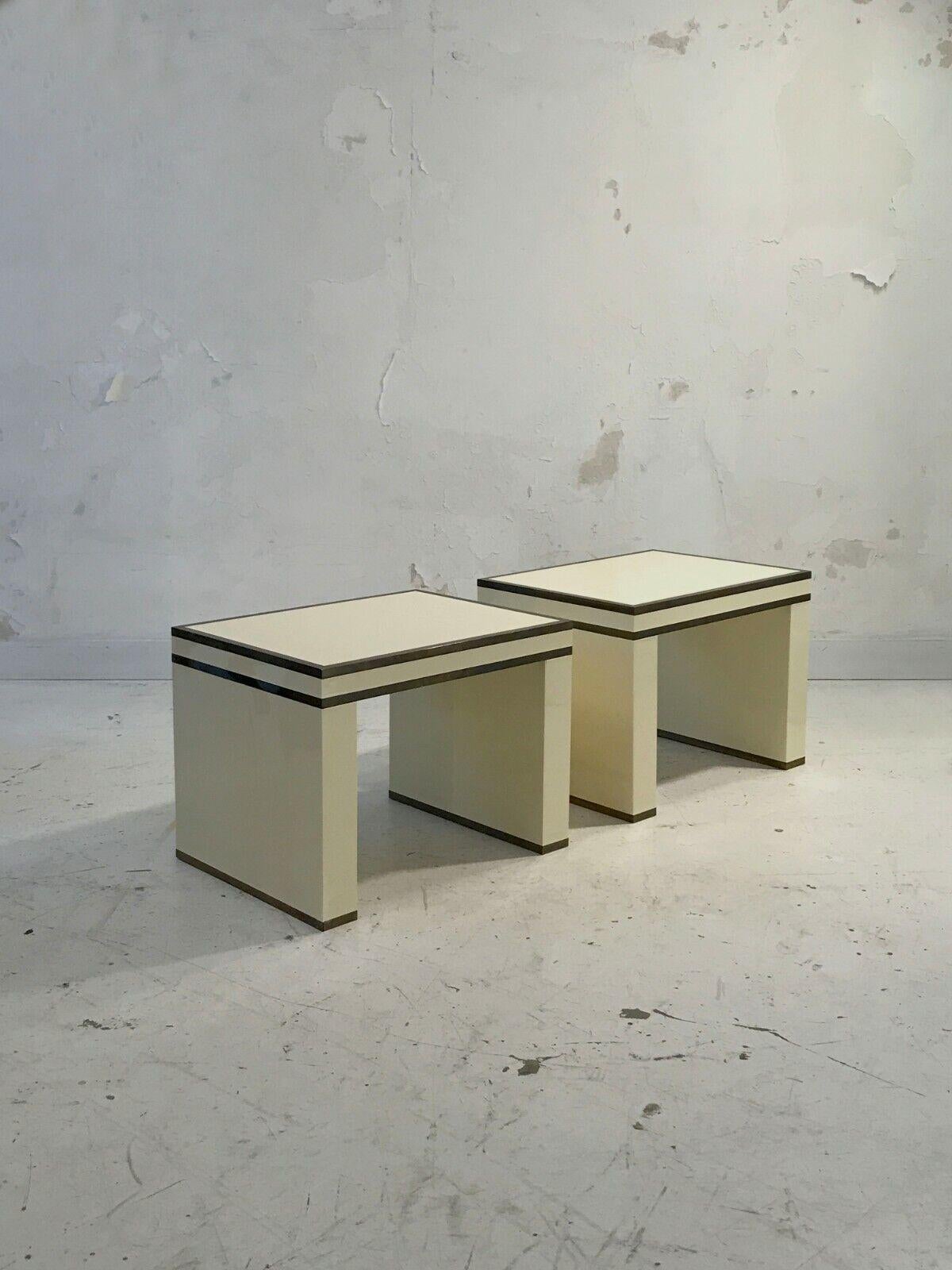 An elegant pair of rectangular U-shaped bedside tables, Art-Deco, Modernist, Cubist, Bauhaus, in butter lacquered wood enhanced with patinated bronze strips of square section, attributed to Maison Jansen, France 1970.