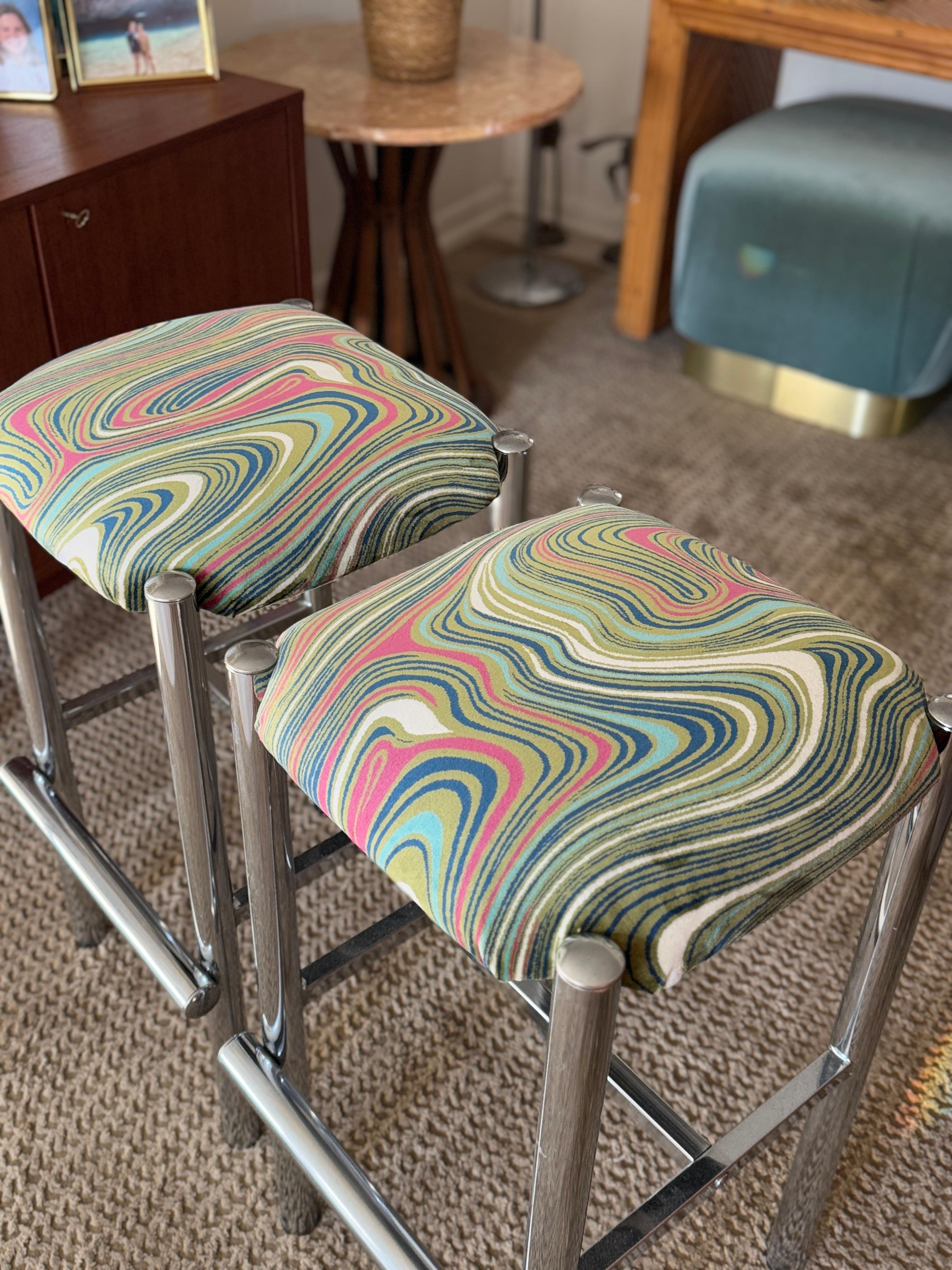 A set of 2 sleek Cal-Style chrome stools reupholstered in a groovy velvet, circa 1970s.  These versatile stools tuck out of the way easily and have an extremely heavyweight, sturdy feel and comfortable wider seat. Overall in very good condition.