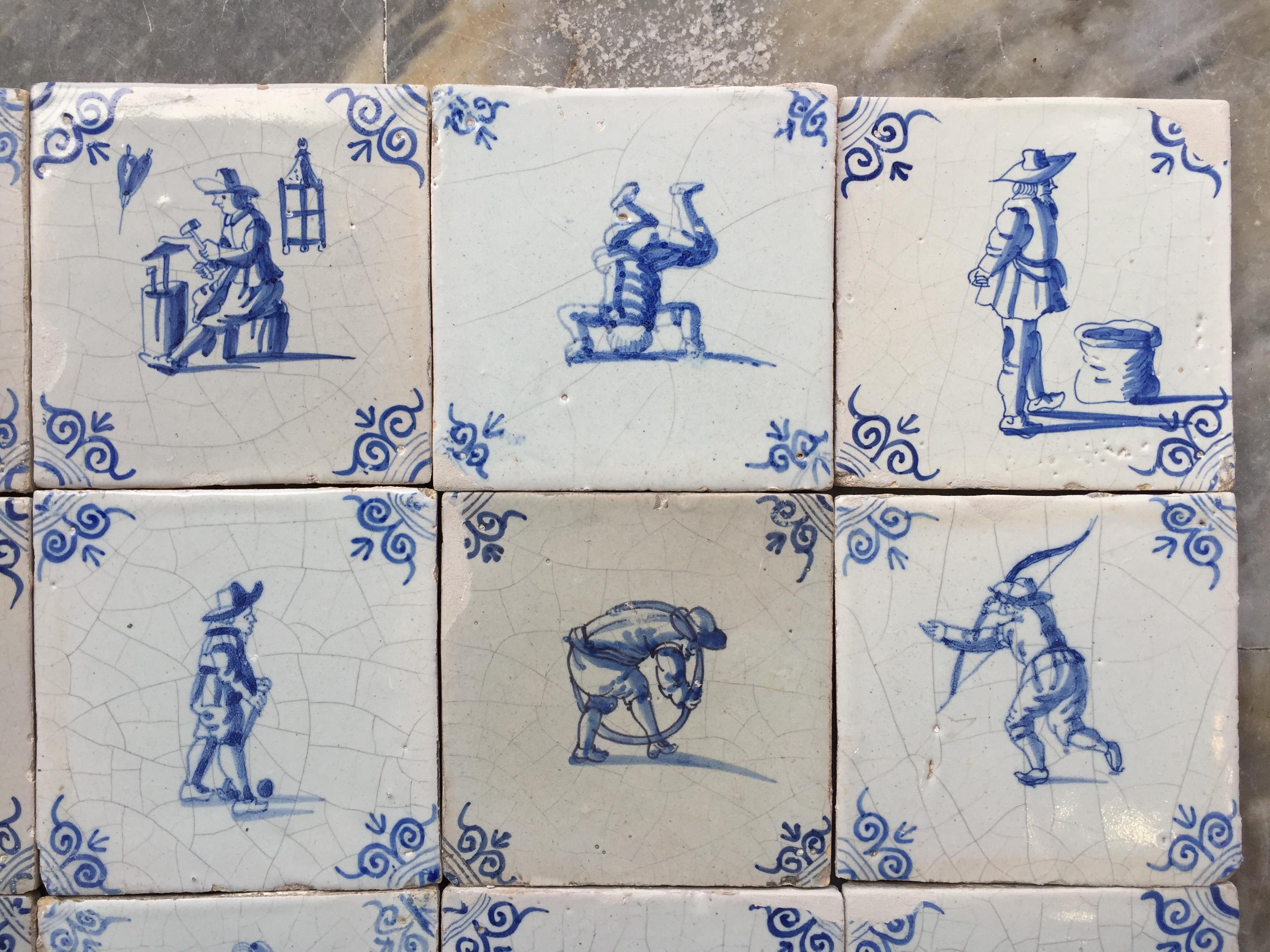 Glazed A set of 20 blue and white Dutch Delft tiles with figures and craftsmen