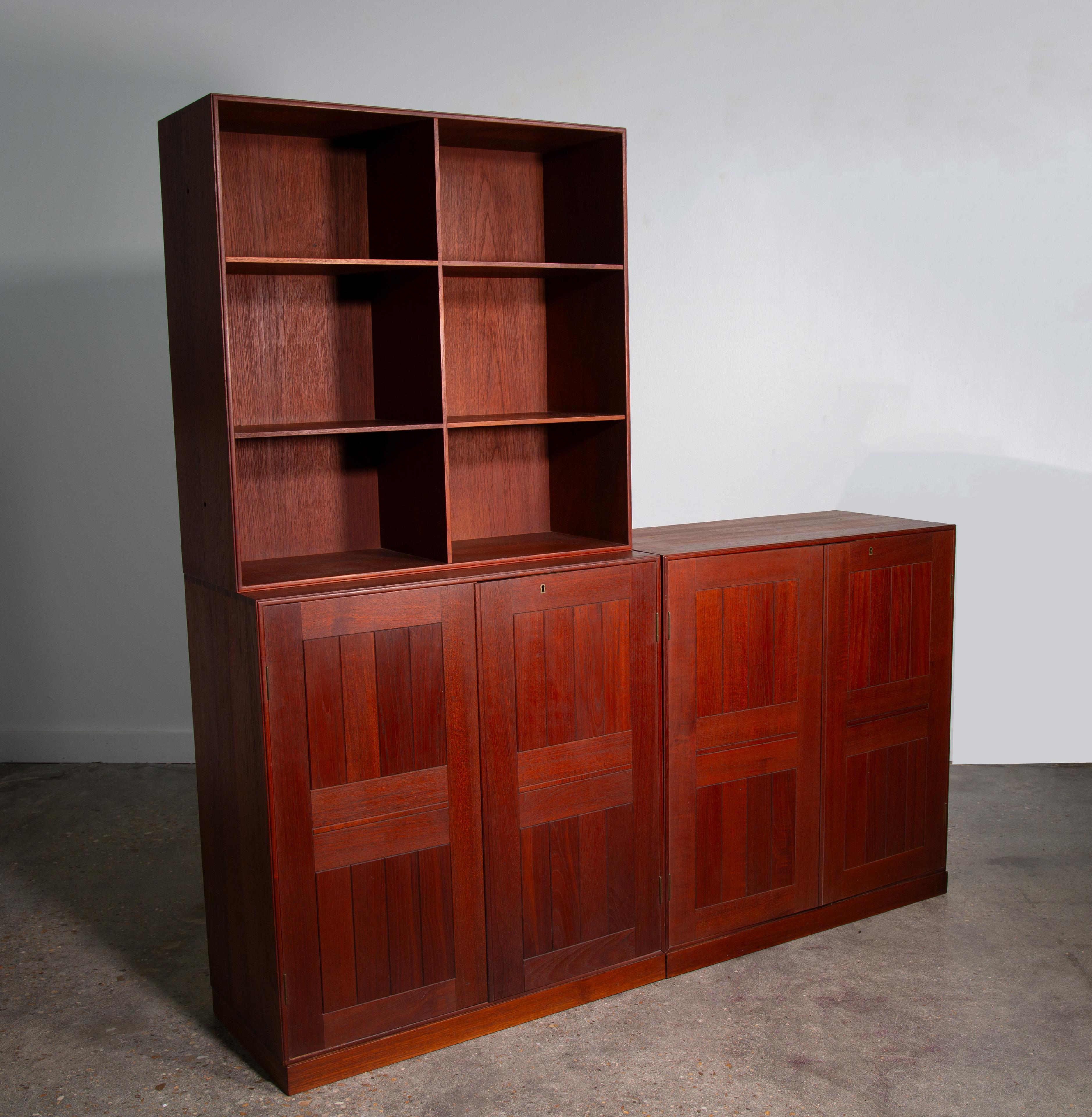 A set of three cabinets designed by Mogens Koch for Rud Rasmussen in Teak.  The set includes two cabinets with doors and an open bookshelf. The set includes three removable plinths so these can be used in one long  3x1  configuration or stacked