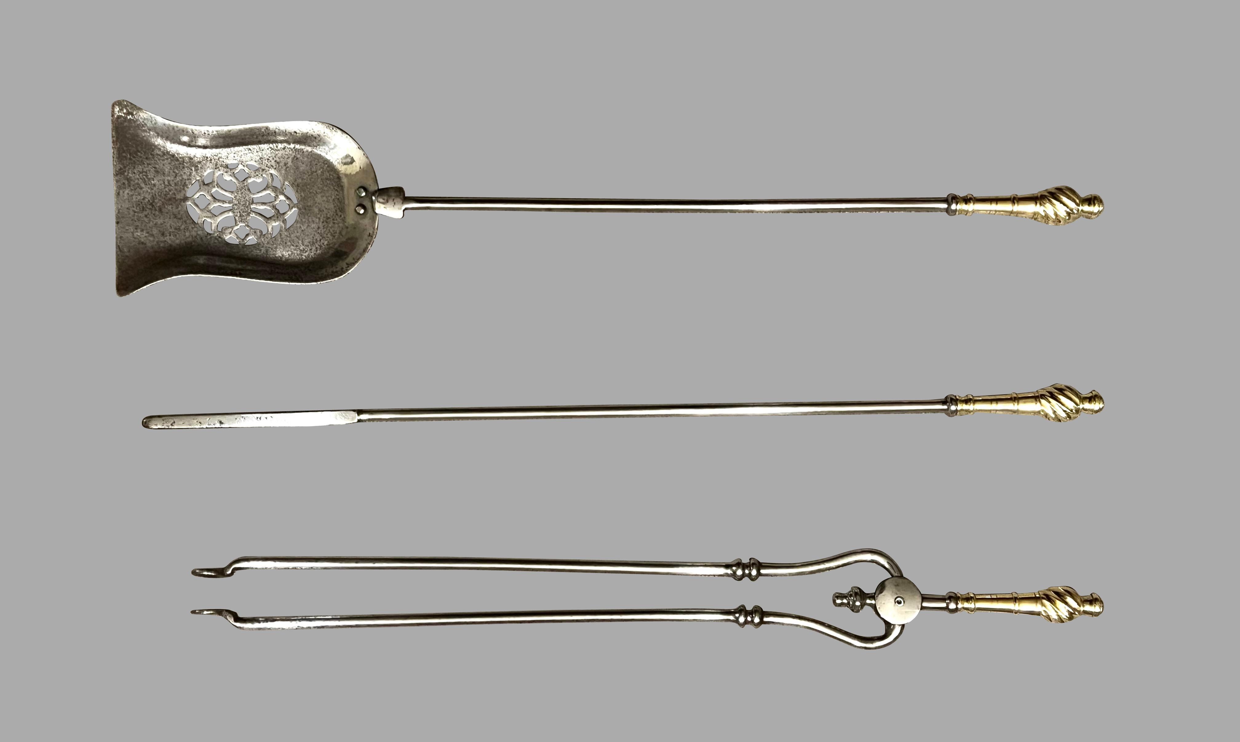 Un raffinato set di 3 attrezzi da fuoco di epoca vittoriana in ottone e acciaio lucido composto da una pala, una pinza e un attizzatoio. Le insolite maniglie a forma di vortice in ottone sono particolarmente attraenti. La pala d'acciaio sagomata è