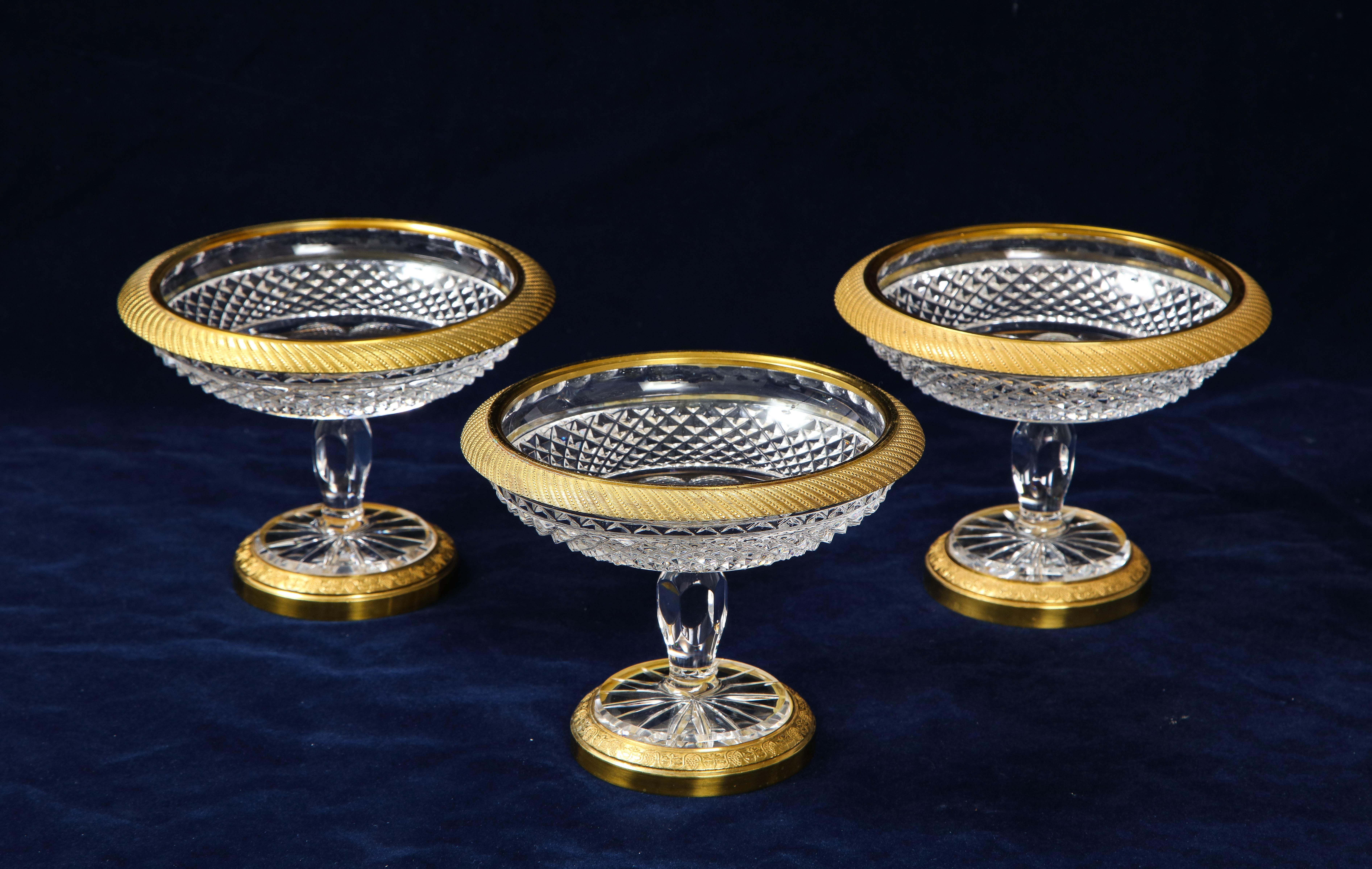 A fabulous set of three French Louis XVI style doré bronze mounted baccarat crystal candy bowls. The crystal of each bowl is beautifully hand diamond-cut with a lattice design and is mounted on a beautiful hand-chased and hand-chiseled doré bronze
