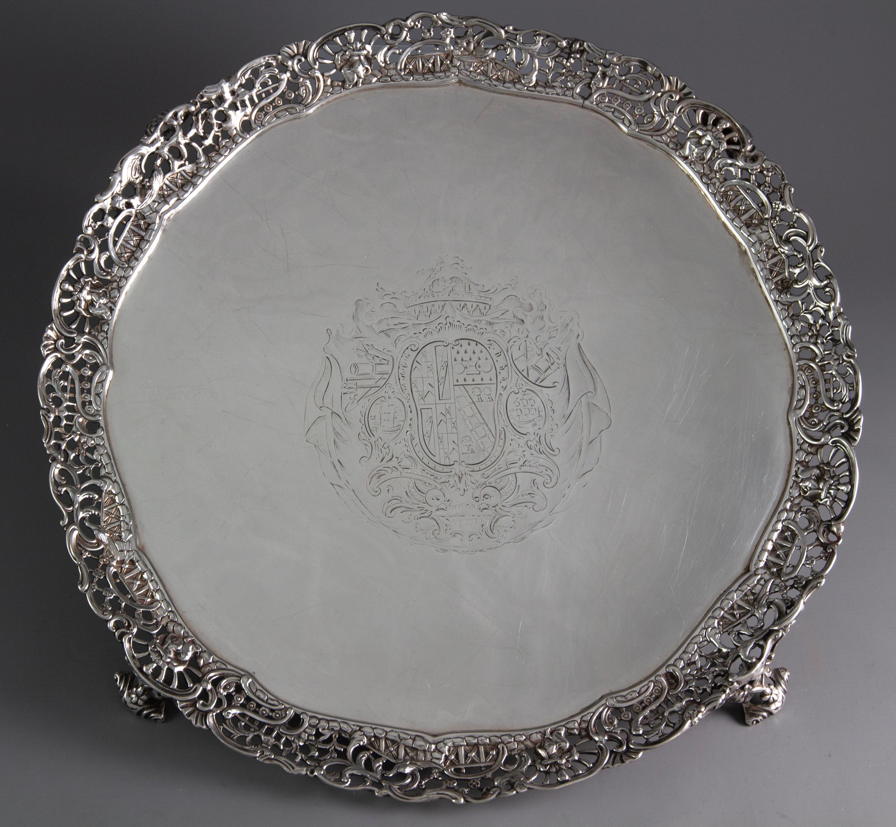 A rare set of 3 early George III silver salvers or trays. Consisting of a large salver accompanied by two smaller salvers or waiters. All with intricately cast, pierced gallery borders with chinoiserie decoration featuring seated figures and birds