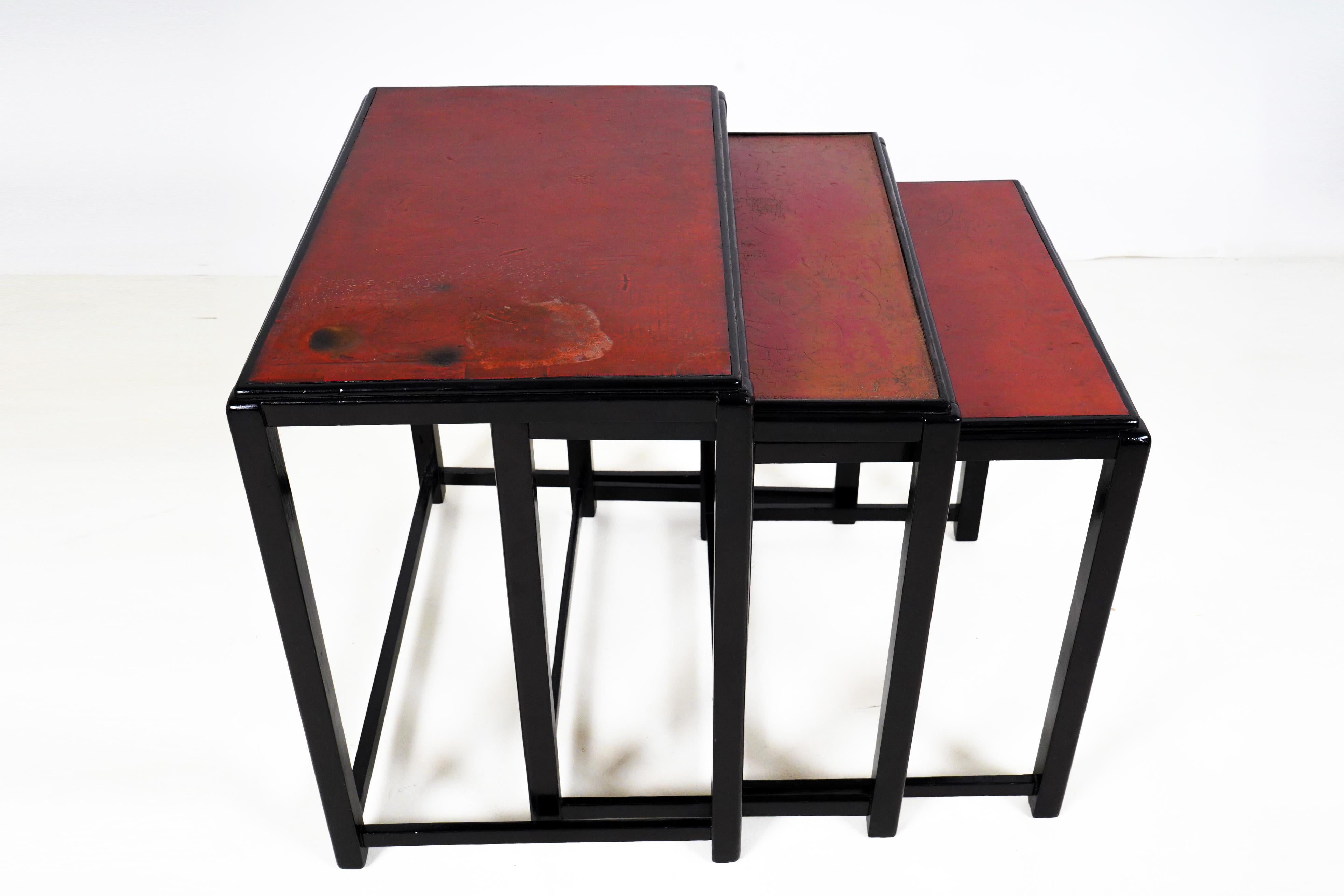 A set of three Bauhaus-inspired Hungarian Art Deco side tables. These tables are as beautiful as they are practical. The solid walnut frames have been French-polished dark, almost black. Their tops are red lacquer and have been gently re-glossed,