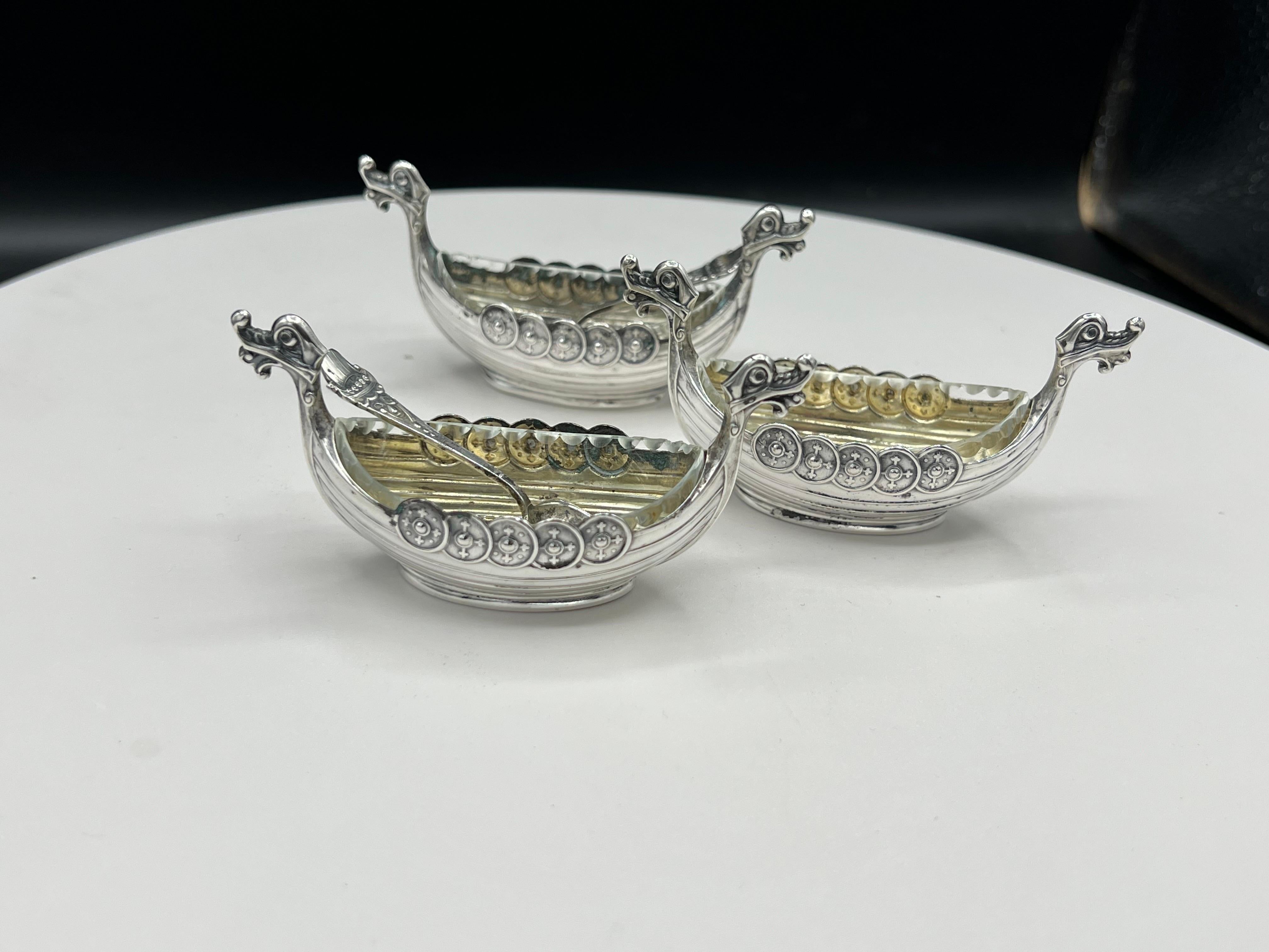 A Set of 3 Viking ship silver salts with 2 spoons 
3 glass inserts.