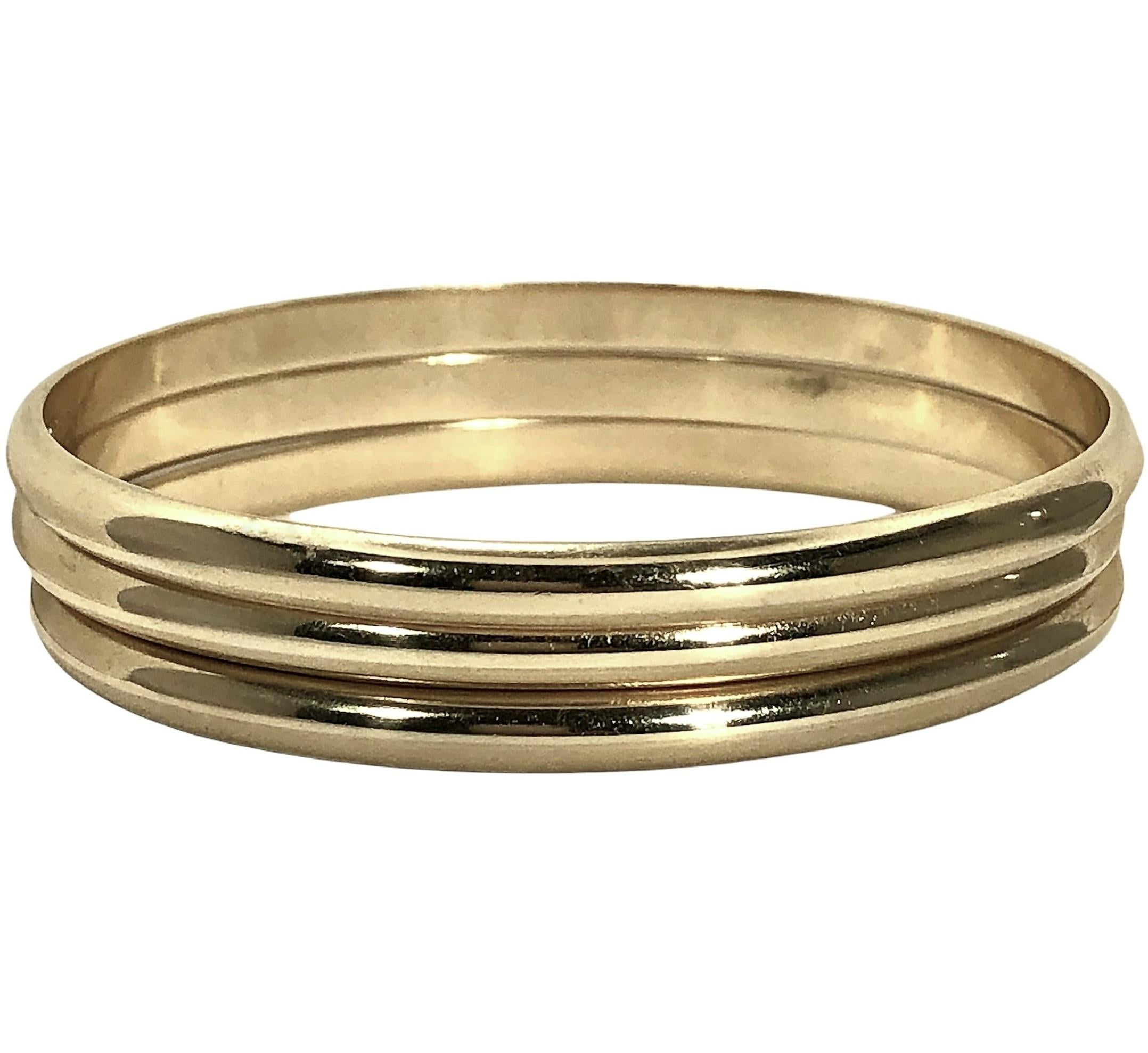 This vintage Tiffany & Co. 14K yellow gold, three piece bangle bracelet set is the epitome of tailored jewelry. The outside of each bangle is curved or bombe style while the inside is smooth and flat, making them extremely comfortable to wear. The