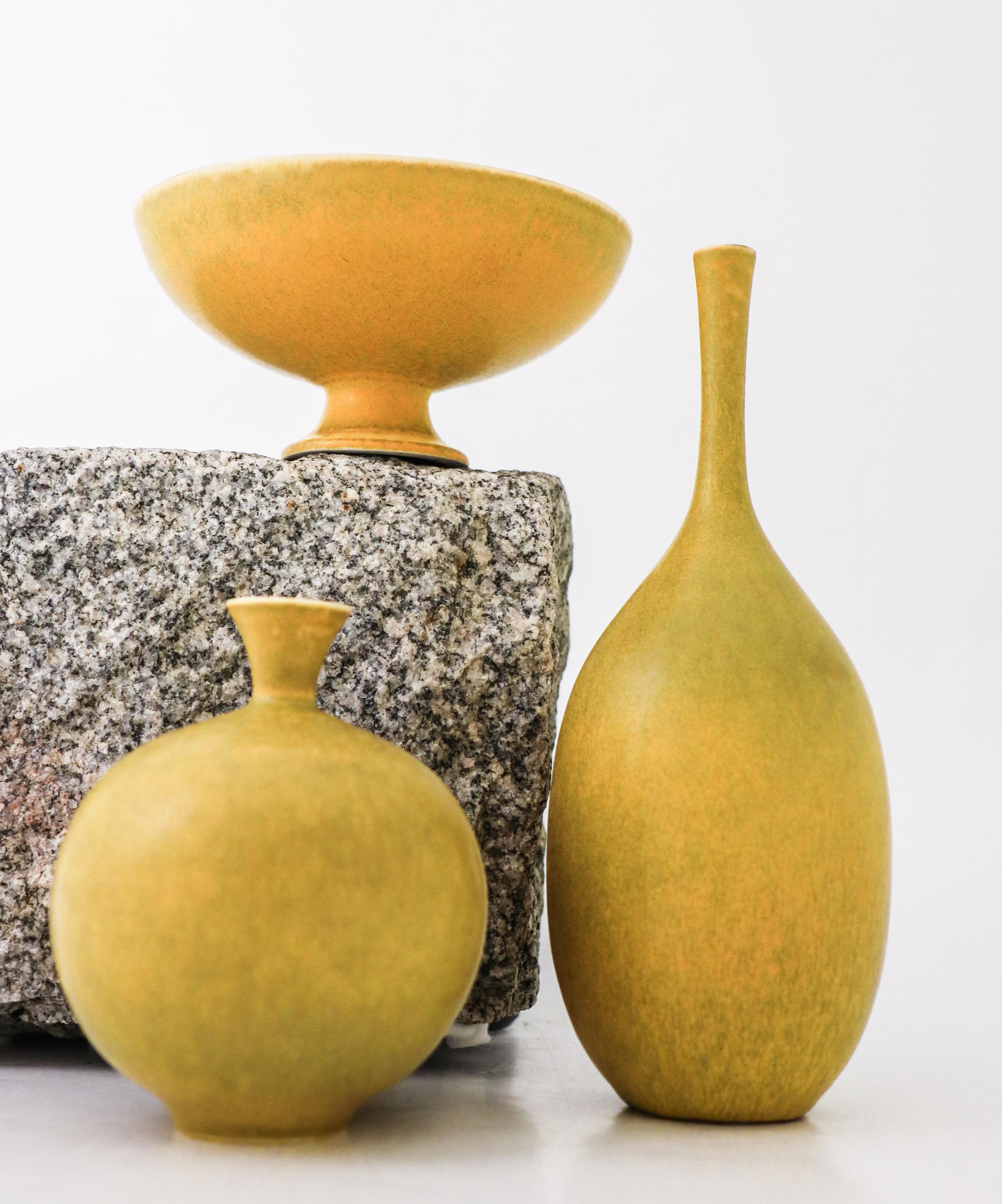 A lovely set of 2 yellow vases and one bowl with the same yellow color designed by Sven Wejsfelt in 1990 at Gustavsberg in Sweden. The bowl is 12,5 cm (5