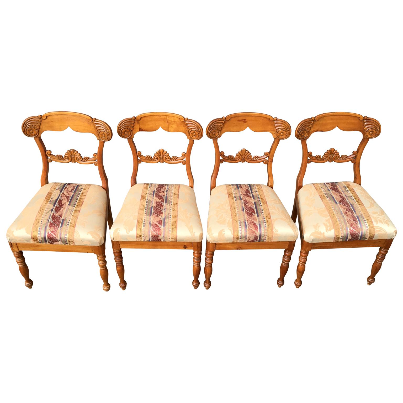 Swedish Biedermeier dining chairs in birch wood from circa 1820-1840, set of four. Lathed front legs, nice warm patina, plentiful carved back and removable sits.