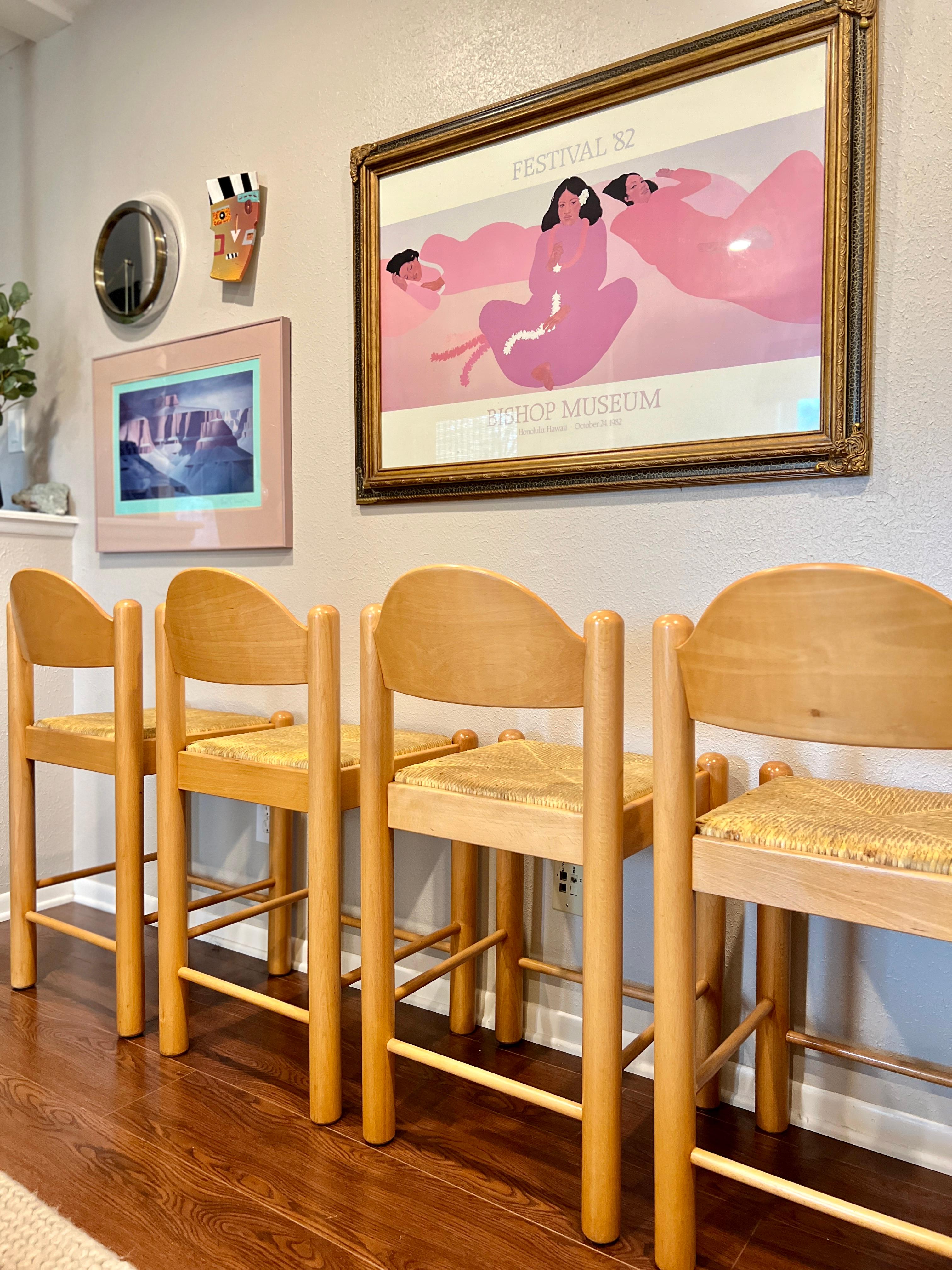 A set of 4 counter stools designed by Hank Lowenstein. The lovely stools feature scalloped backs, original rush woven seats, and the most sturdy frames I have ever encountered. Stamped “made in Italy” on the bottom. They have been completely