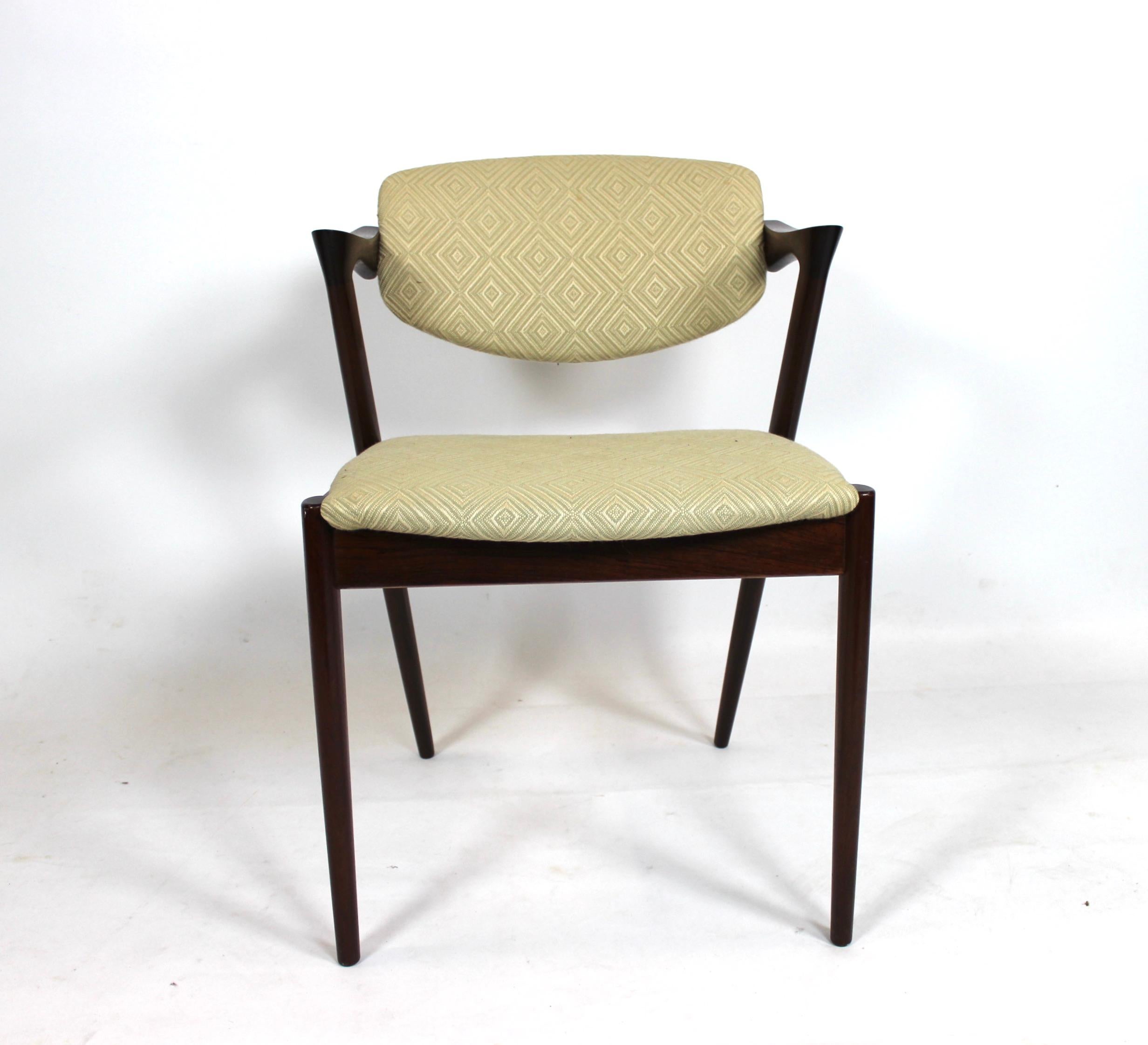 A set of 4 dining chairs, model 42, designed by Kai Kristiansen and manufactured by Schou Andersen in the 1960s. The chairs are of rosewood and upholstered in light wool fabric.
 