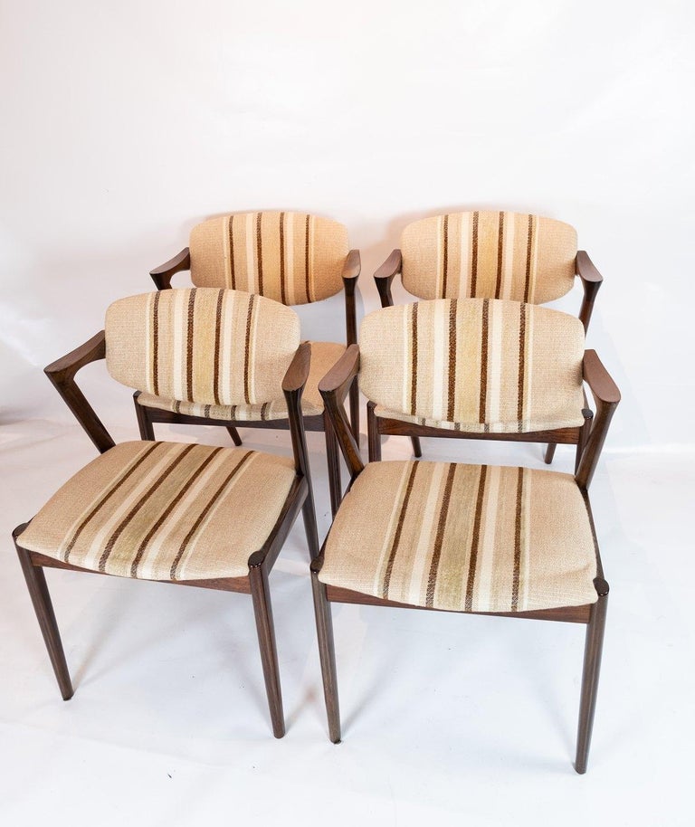 A set of 4 dining chairs, model 42, designed by Kai Kristiansen and manufactured by Schou Andersen in the 1960s. The chairs are of rosewood and upholstered in light striped wool fabric.