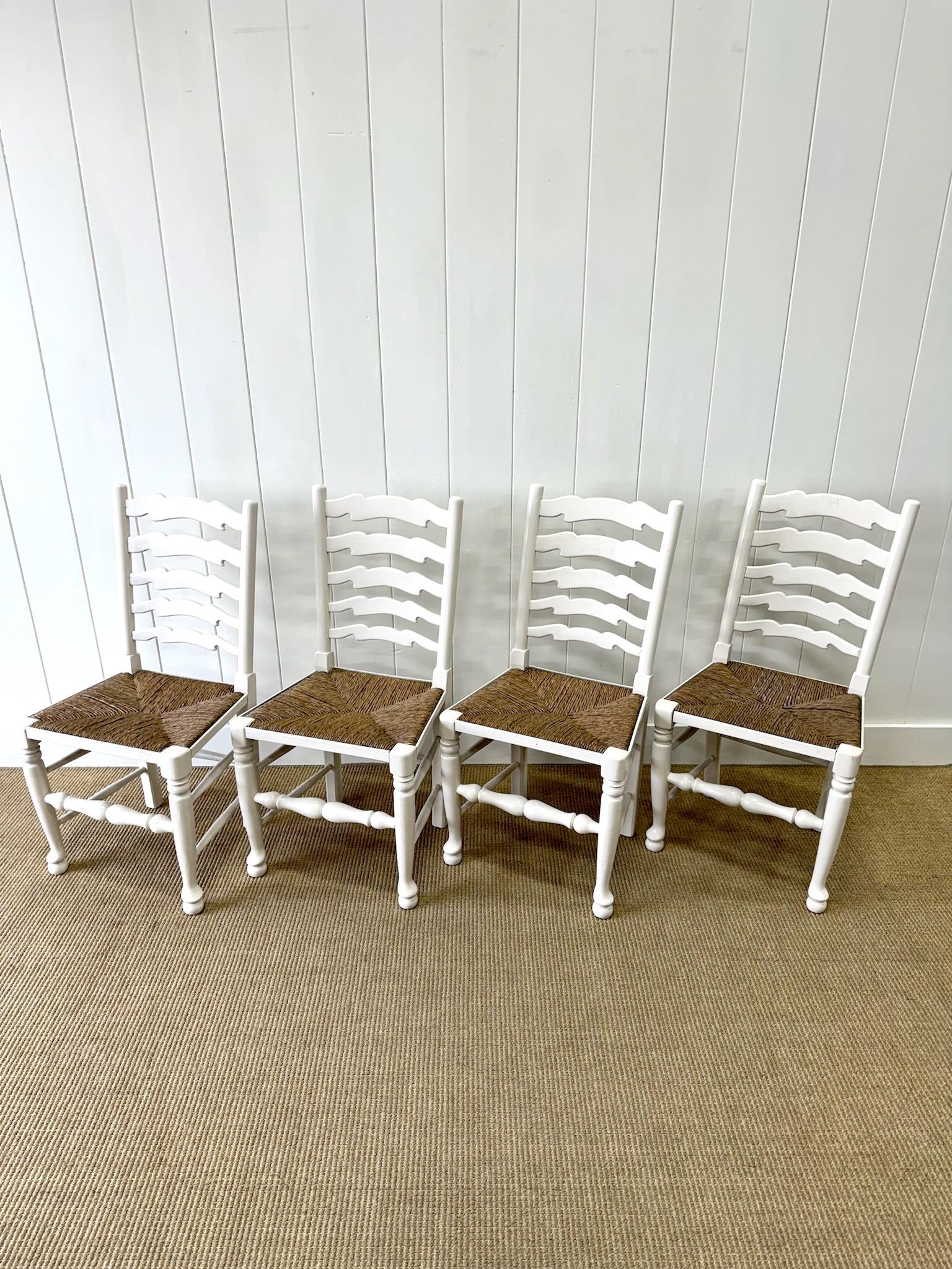 A charming set of 4 English side chairs with solid rush seats.  Lovely fresh Muslin paint. A graceful silhouette sets these chairs apart. Stretchers add support. These are solid chairs, but should not be 