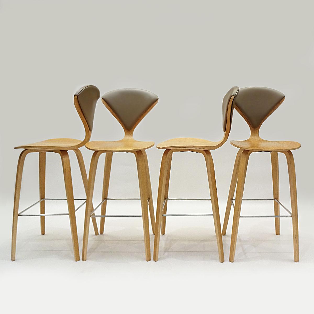A set of Norman Cherner designed bar stools in oak veneered plywood with chrome bases and vinyl back pads.

Originally designed in 1958 these Norman Cherner bar stools echo many of the features that Cherner was famous for. These include the