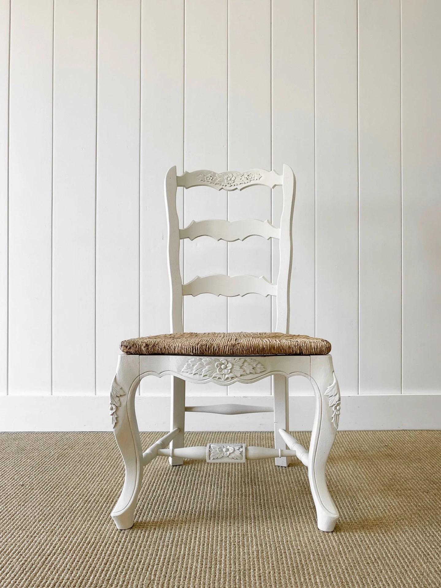A pretty set of white painted French oak ladder back side chairs with nice warm rush seats. Painted chairs can be a lovely contrast to pine tables! Rock solid in joint. Some of the rush on the seats has split,, and is worn - should possibly have