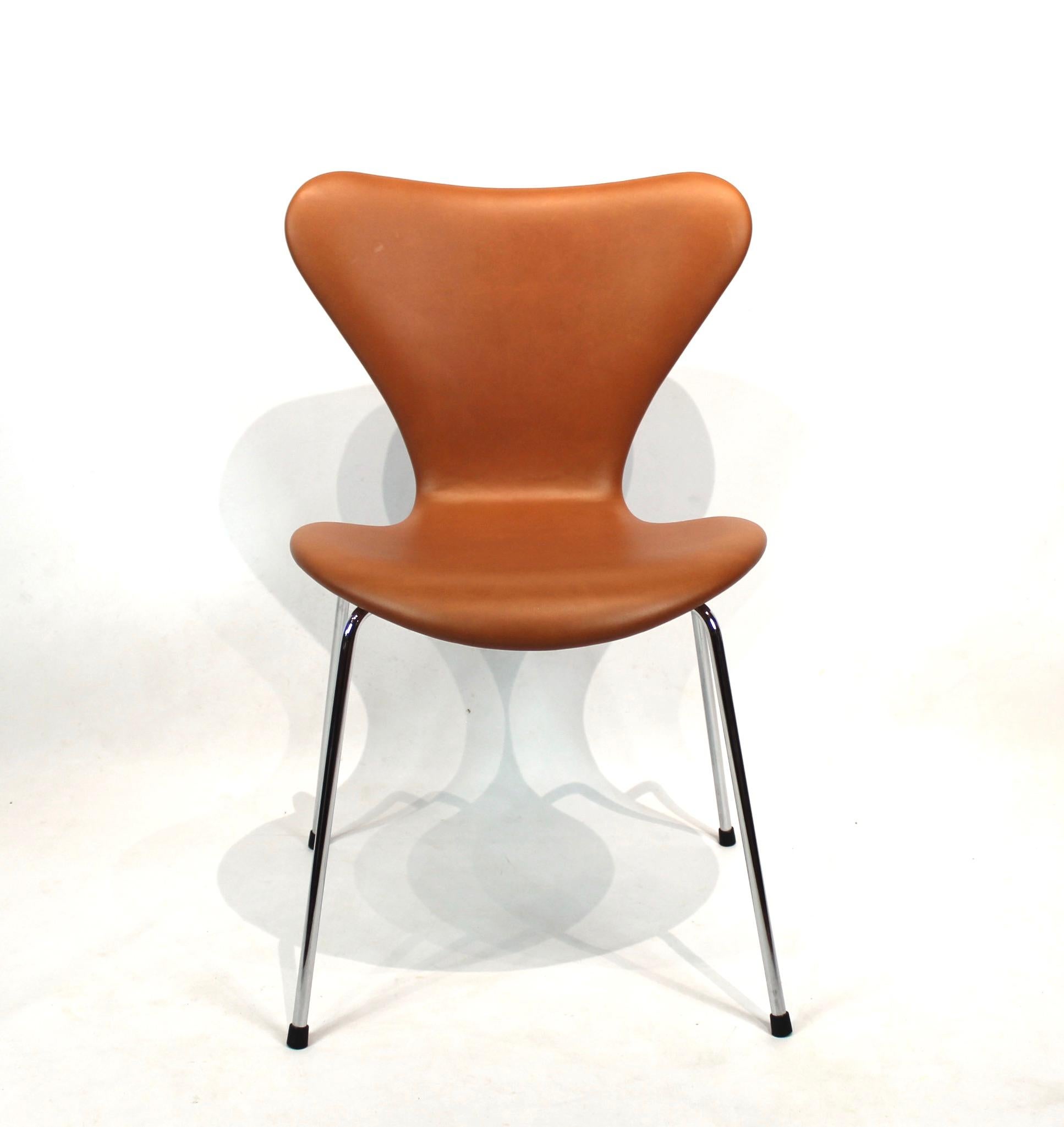 A set of 4 seven chairs, model 3107, designed by Arne Jacobsen and manufactured by Fritz Hansen. The chairs are upholstered in cognac classic leather and in great used condition. We can upholster more as wanted. The chair was, according to Jacobsen,