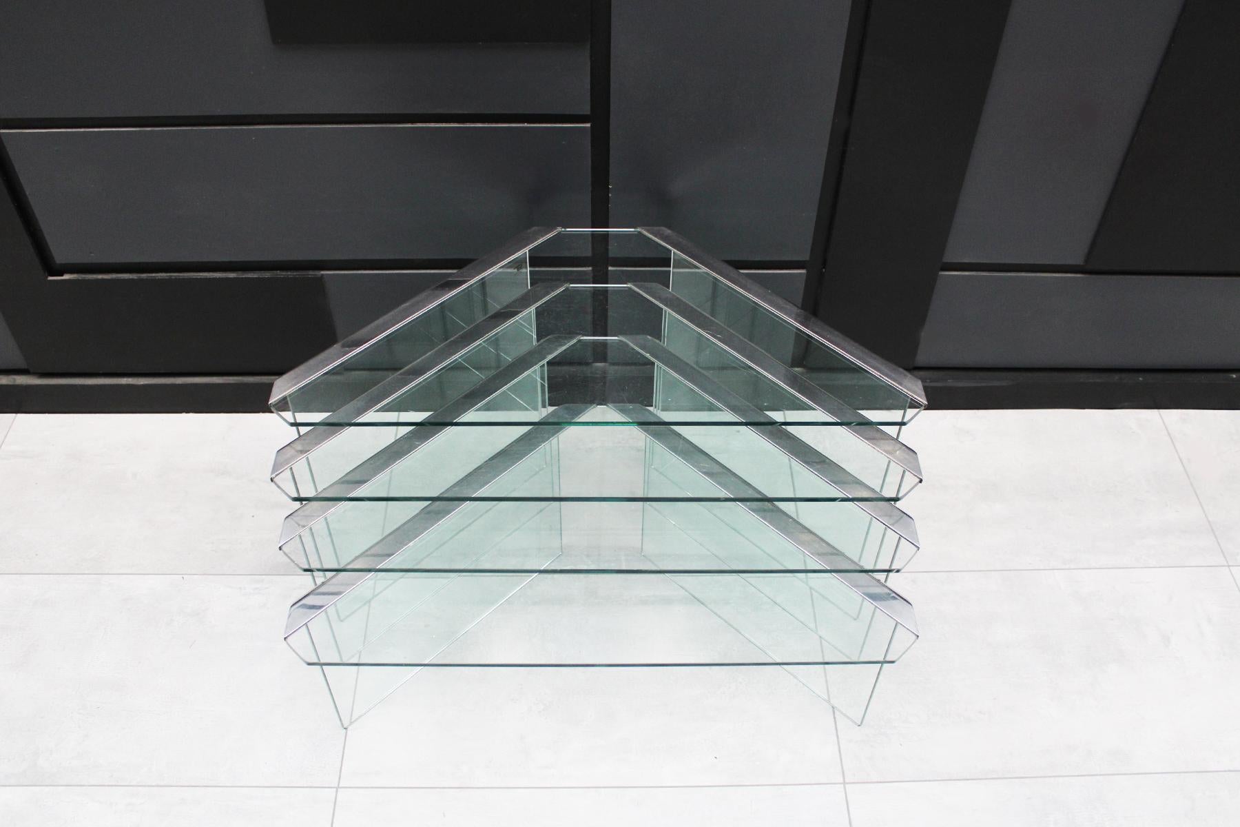 A classic set of 1970s nesting tables by Pierangelo Gallotti for Gallloti & Radice in clear 8mm tempered glass with chrome frames. This clever triangular design allows for all the tables to be stacked away in a small footprint but then can also be