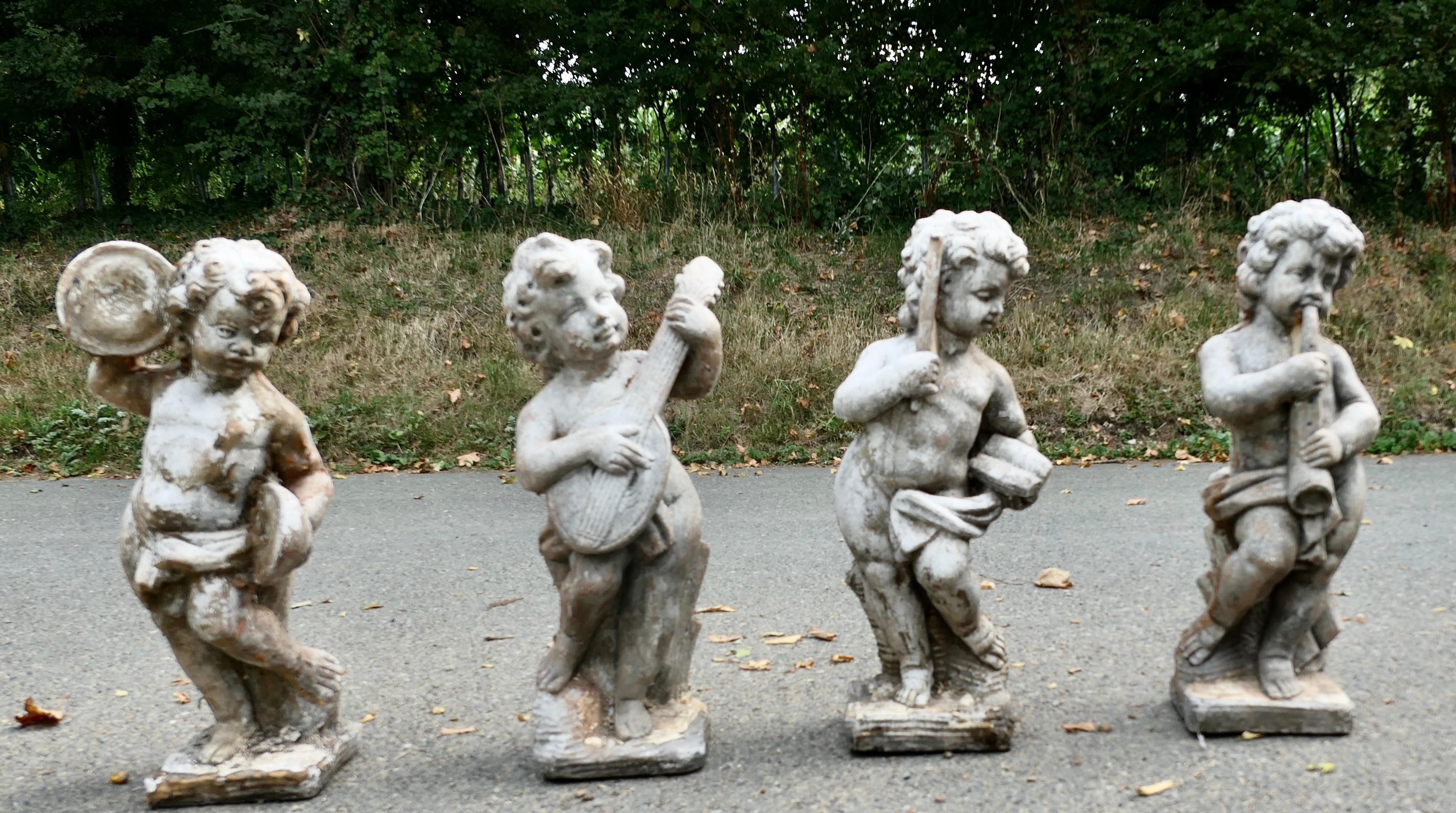A Set of 4 Weather Worn Cherub Statues with Instruments

This is a wonderful set they are around 100 years old and have been outside all of that time, the patina is really beautiful with old paint, moss and general exposure to the elements
The  4