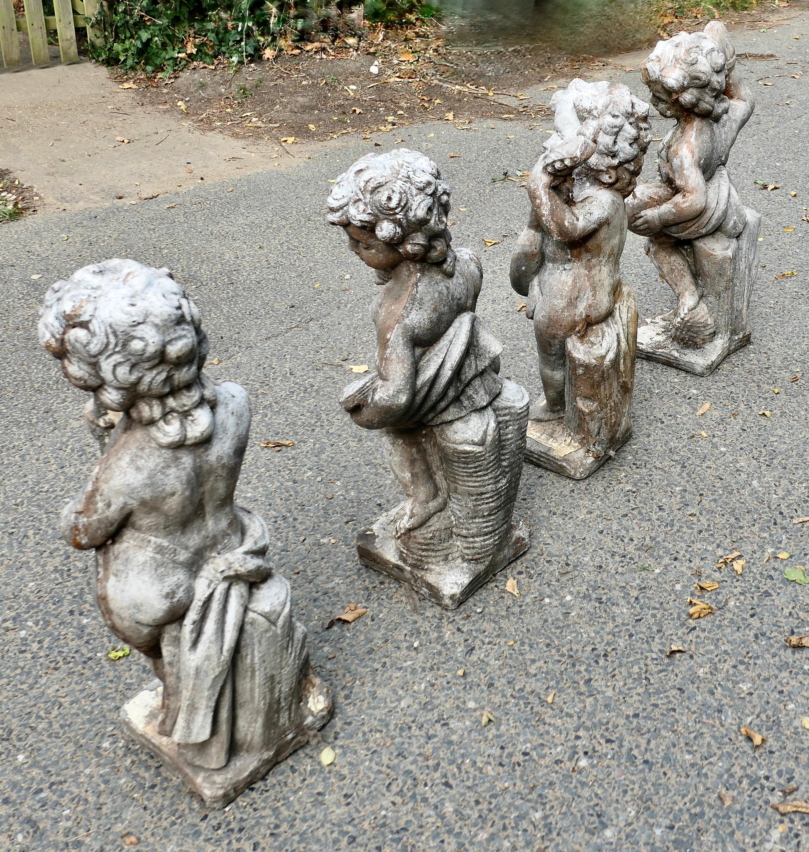 Neoclassical A Set of 4 Weather Worn Cherub Statues with Instruments  This is a wonderful set For Sale