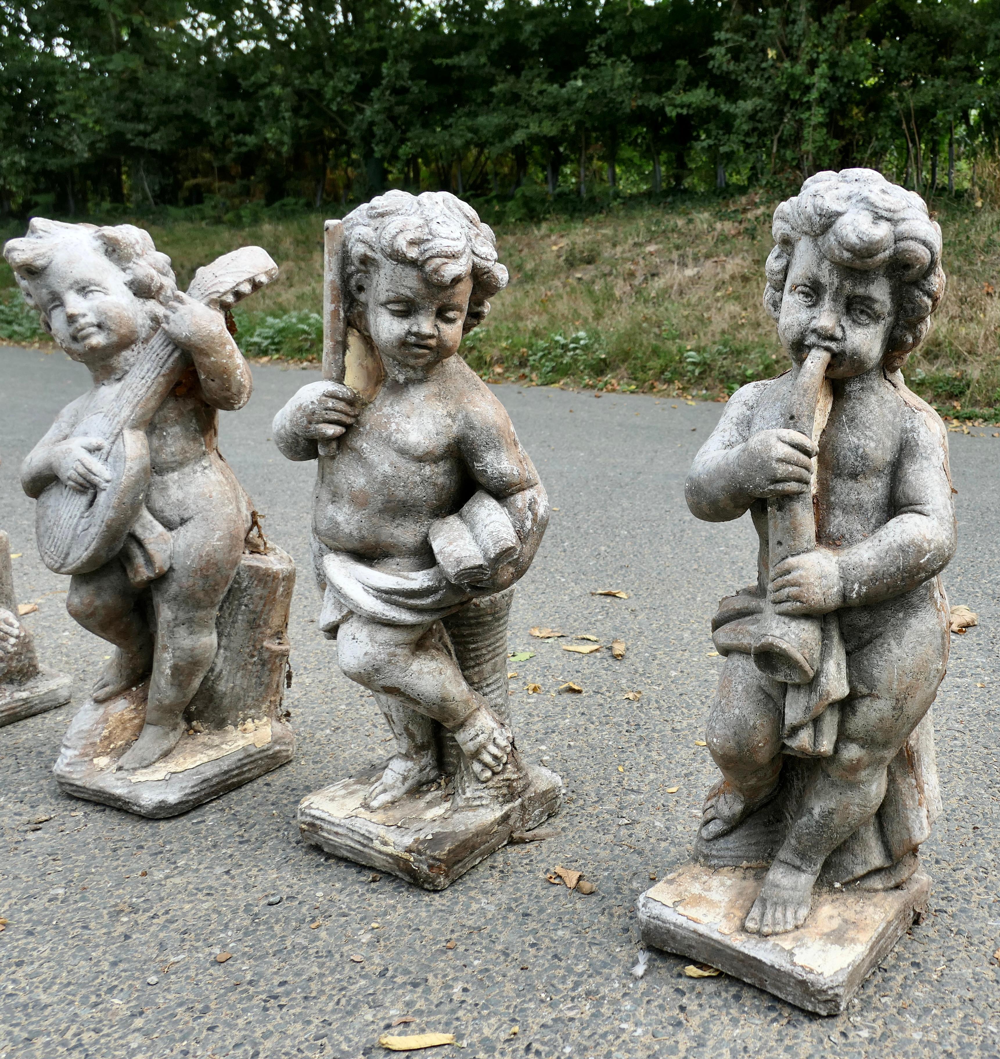 Early 20th Century A Set of 4 Weather Worn Cherub Statues with Instruments  This is a wonderful set For Sale