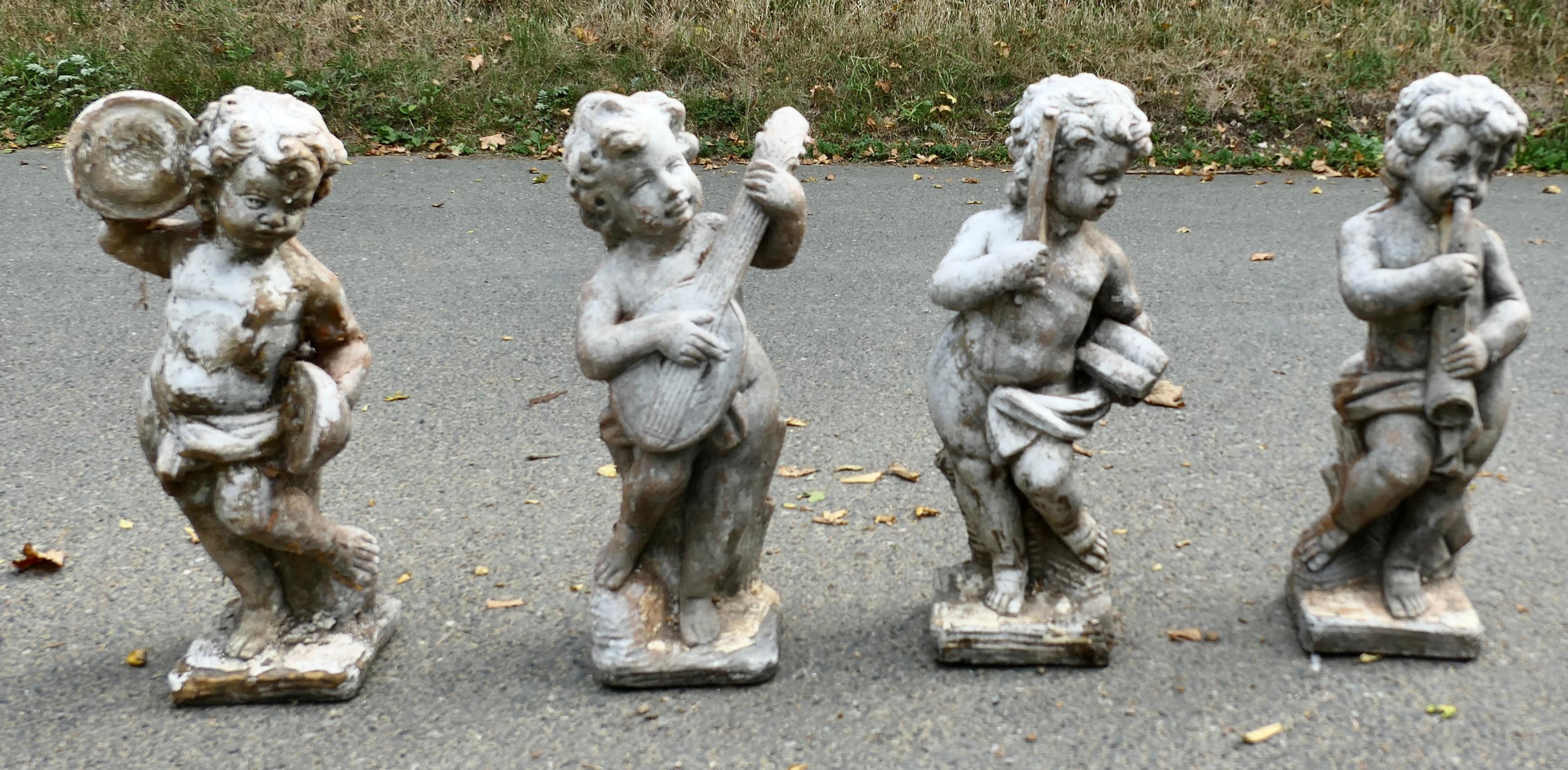Cast Stone A Set of 4 Weather Worn Cherub Statues with Instruments  This is a wonderful set For Sale