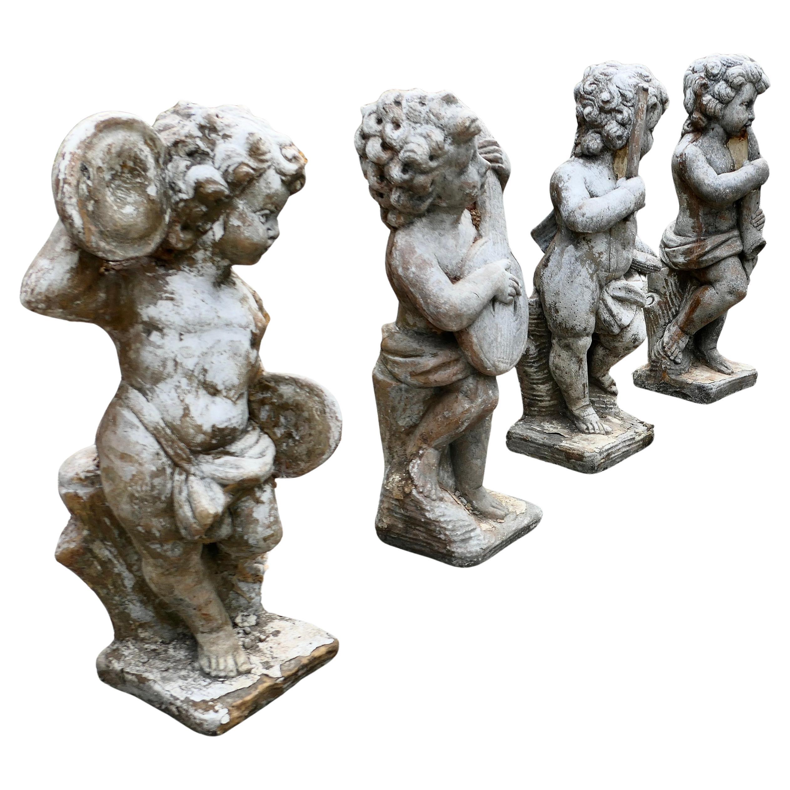 A Set of 4 Weather Worn Cherub Statues with Instruments  This is a wonderful set For Sale