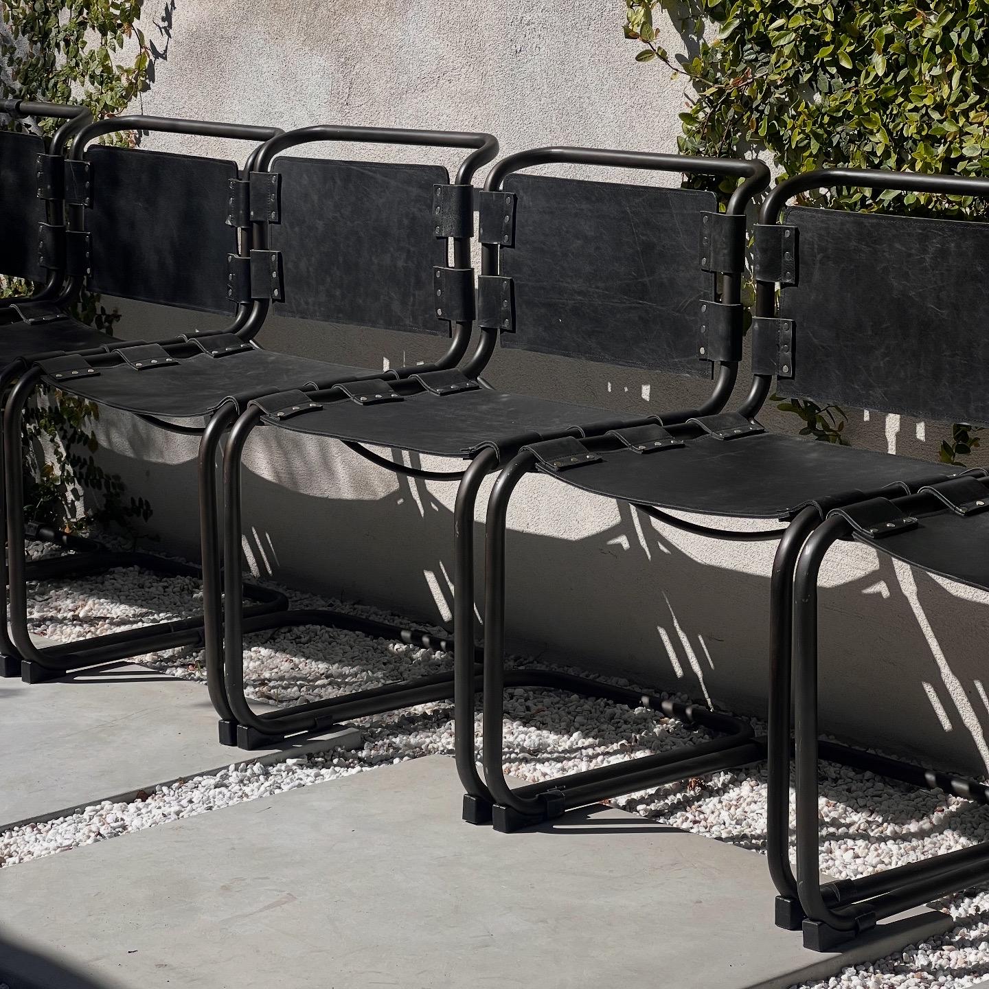 A set of six cantilever metal and leather dining chairs, late 20th century. Cesca meets s&m in these pieces, which are clearly d’apres the iconic Marcel Breuer chairs of the 1920s Bauhaus era which later become deeply associated with mid century