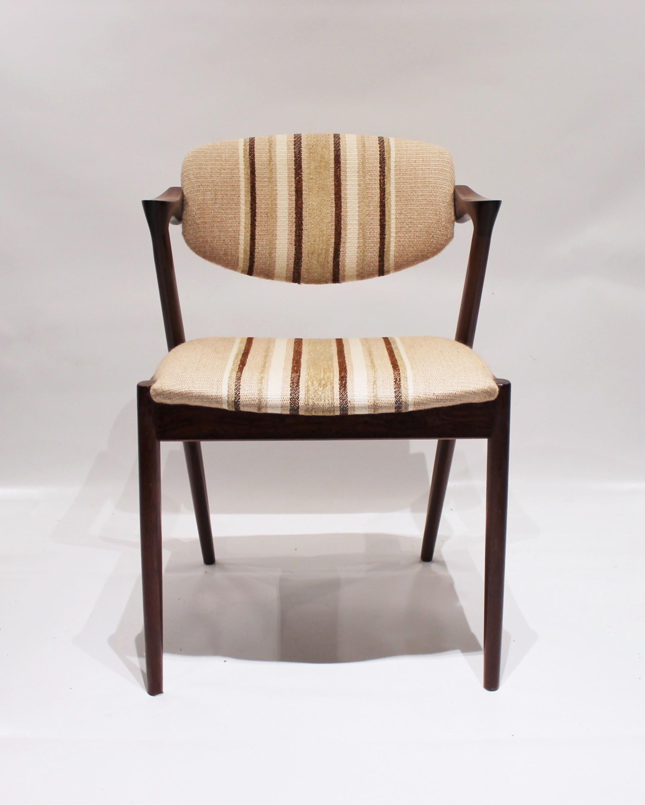 A set of 6 dining chairs, model 42, designed by Kai Kristiansen and manufactured by Schou Andersen in the 1960s. The chairs are of rosewood and upholstered in light striped wool fabric. They are also in great vintage condition.