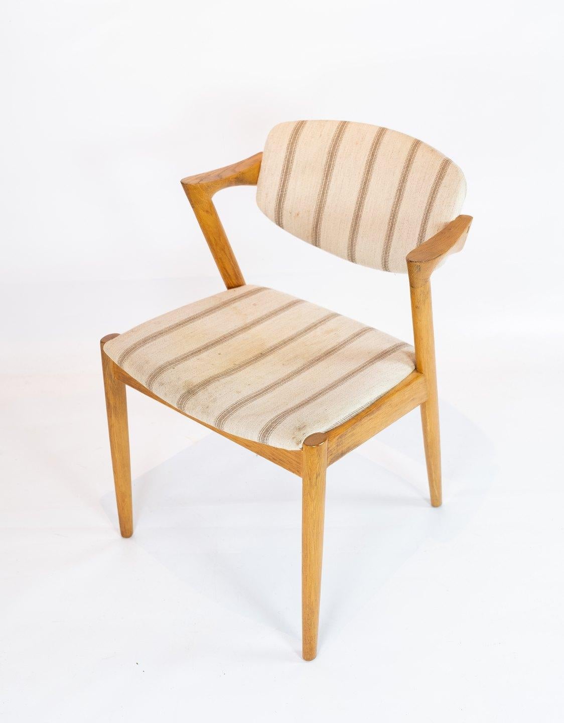 A set of 6 dining chairs, model 42, designed by Kai Kristiansen and manufactured by Schou Andersen in the 1960s. The chairs are of oak and upholstered in light striped wool fabric. The chairs will be looked after by our workshop and reupholstered if