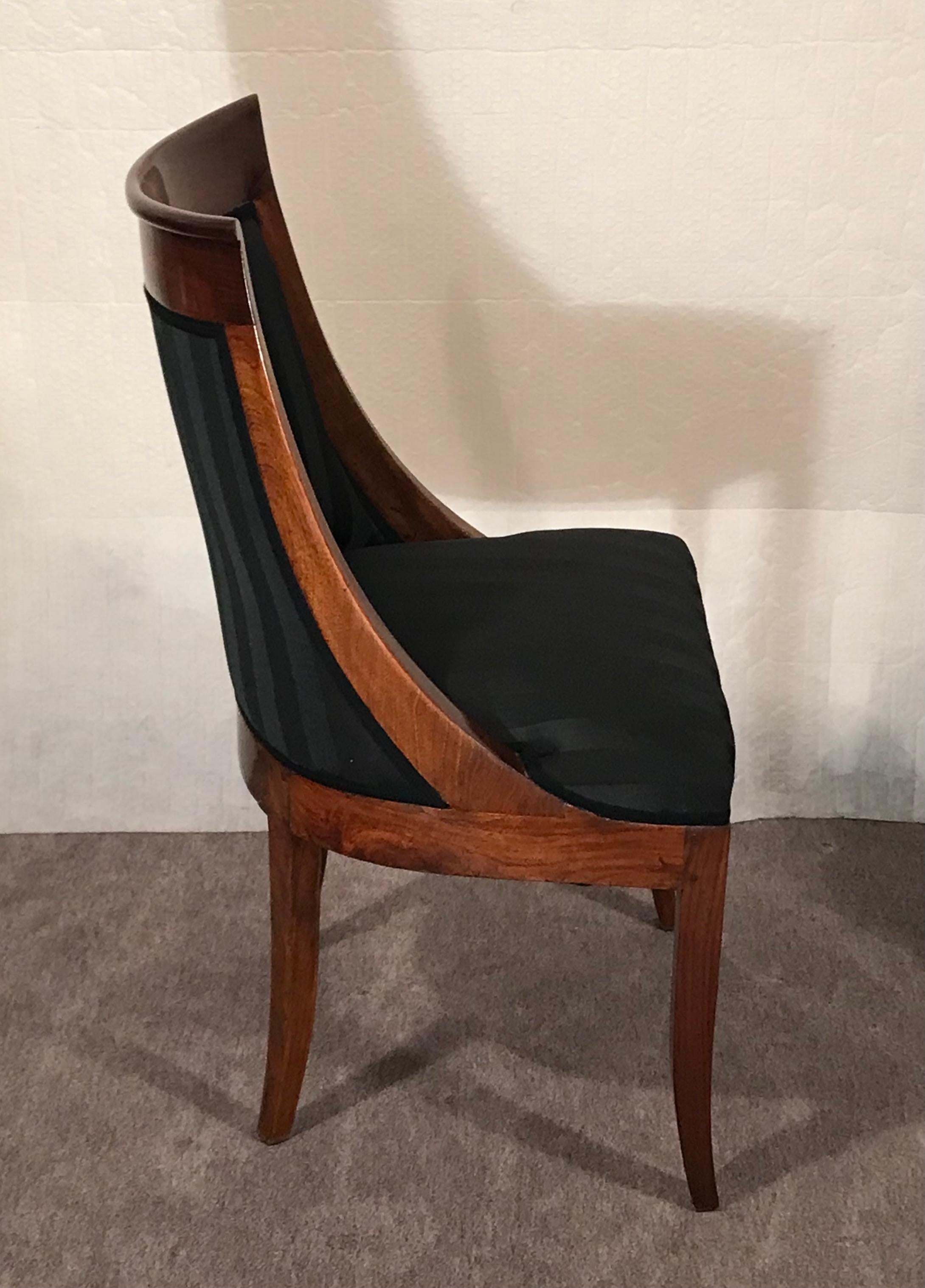 This unique and original set of 6 early 19th century Empire barrel chairs stands out for its elegant design. The chairs feature a beautiful walnut veneer. The chairs have a new upholstery and are covered with a black JAB Anstoetz fabric. They are