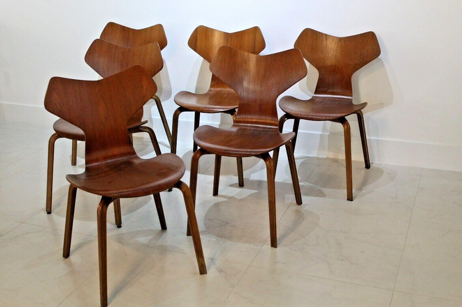 This set of charming design classics are made from Teak and have a beautiful vintage patina. 
The Grand Prix chair from 1957 is the only shell chair by Arne Jacobsen that was not designed with steel legs. 
The chair, which is made entirely in wood,