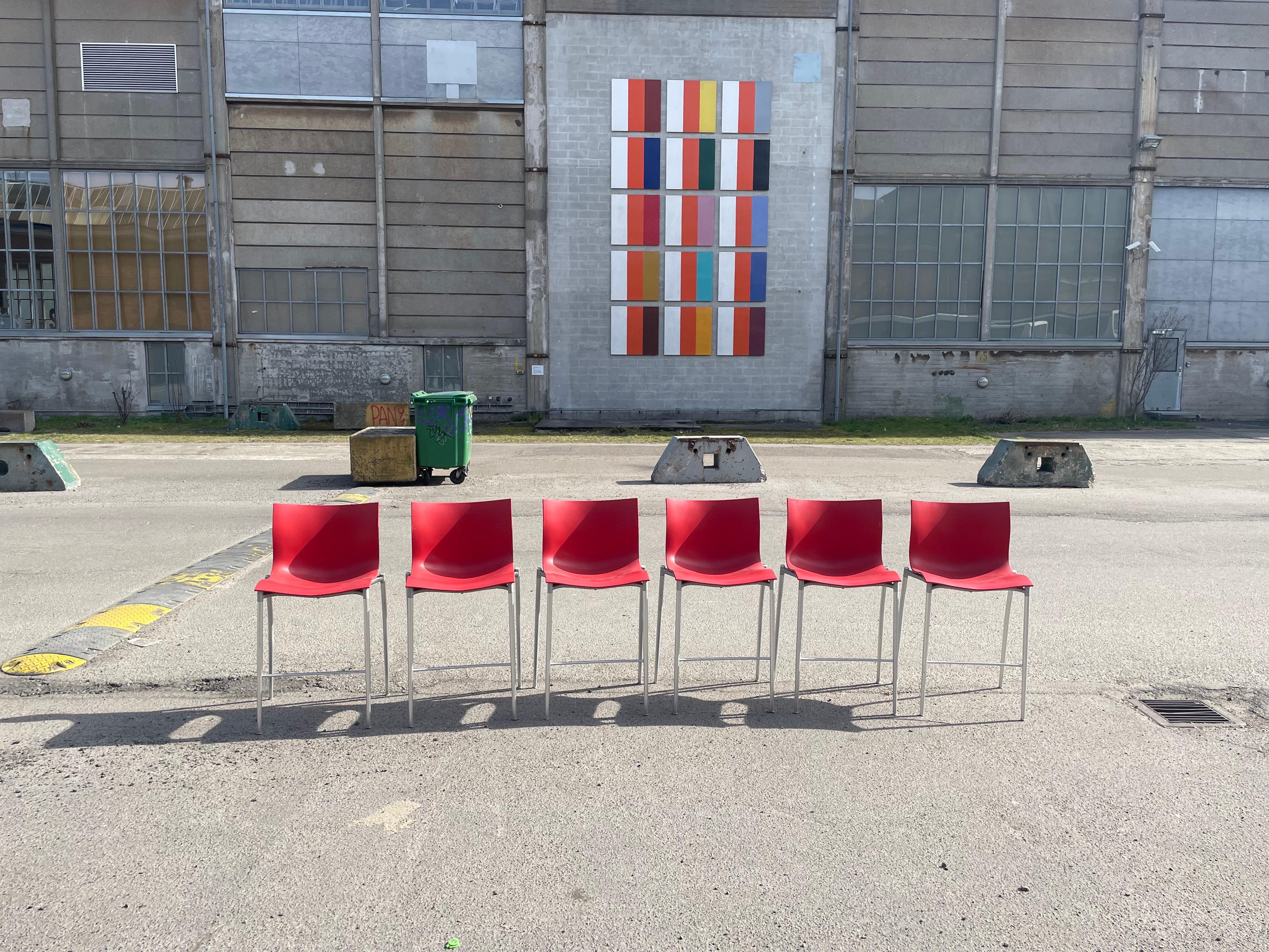 Set of 6 red bar stools by renowned designer Philippe Starck, crafted exclusively for Driade. 
Crafted with precision and innovation, each stool boasts a striking red hue that adds a pop of vibrancy to your decor. But it's not just about looks –