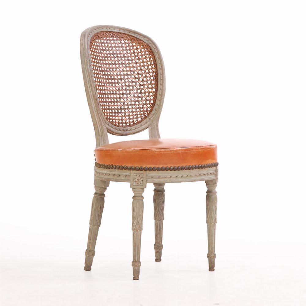 A graceful set of six Italian painted and carved side chairs in the Neoclassical (or Louis XVI) style. Each chair features an oval caned back panel framed in delicate carved details, paired with generously overstuffed seats for added comfort. The