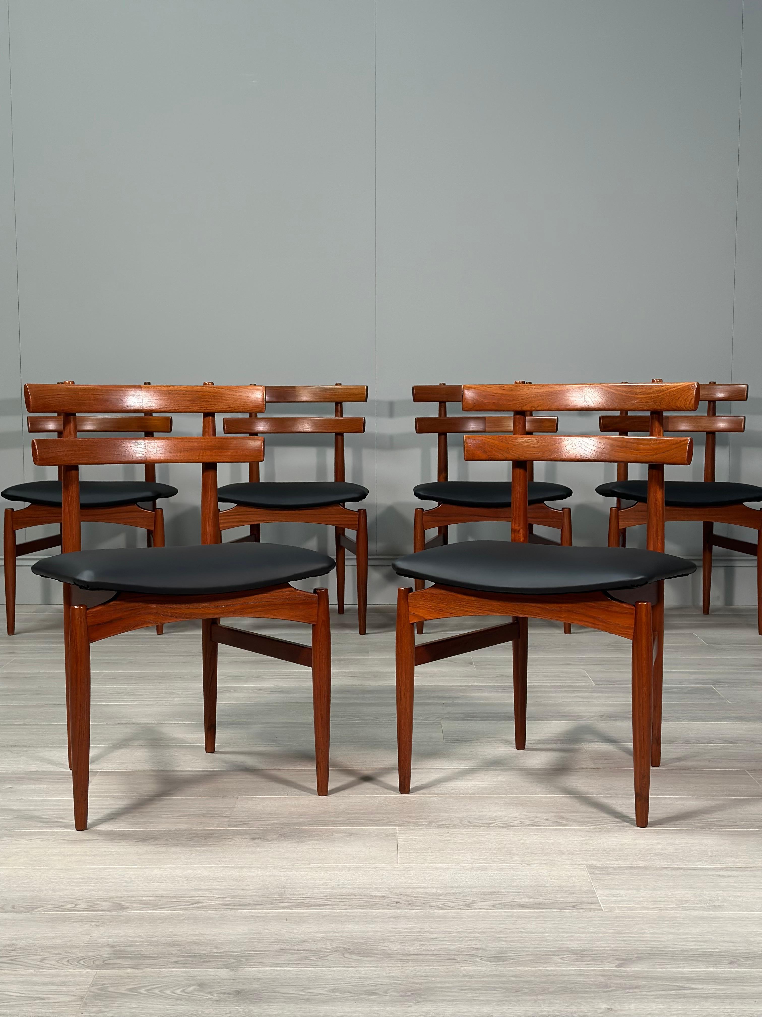 A rarely seen set of 6 teak dining chairs designed and produced by Poul Hundevad, Denmark. The chairs have a stylish curved back which has a split contrast in grain with a floating seat freshly reupholstered in black vinyl. A quality set of 6 in