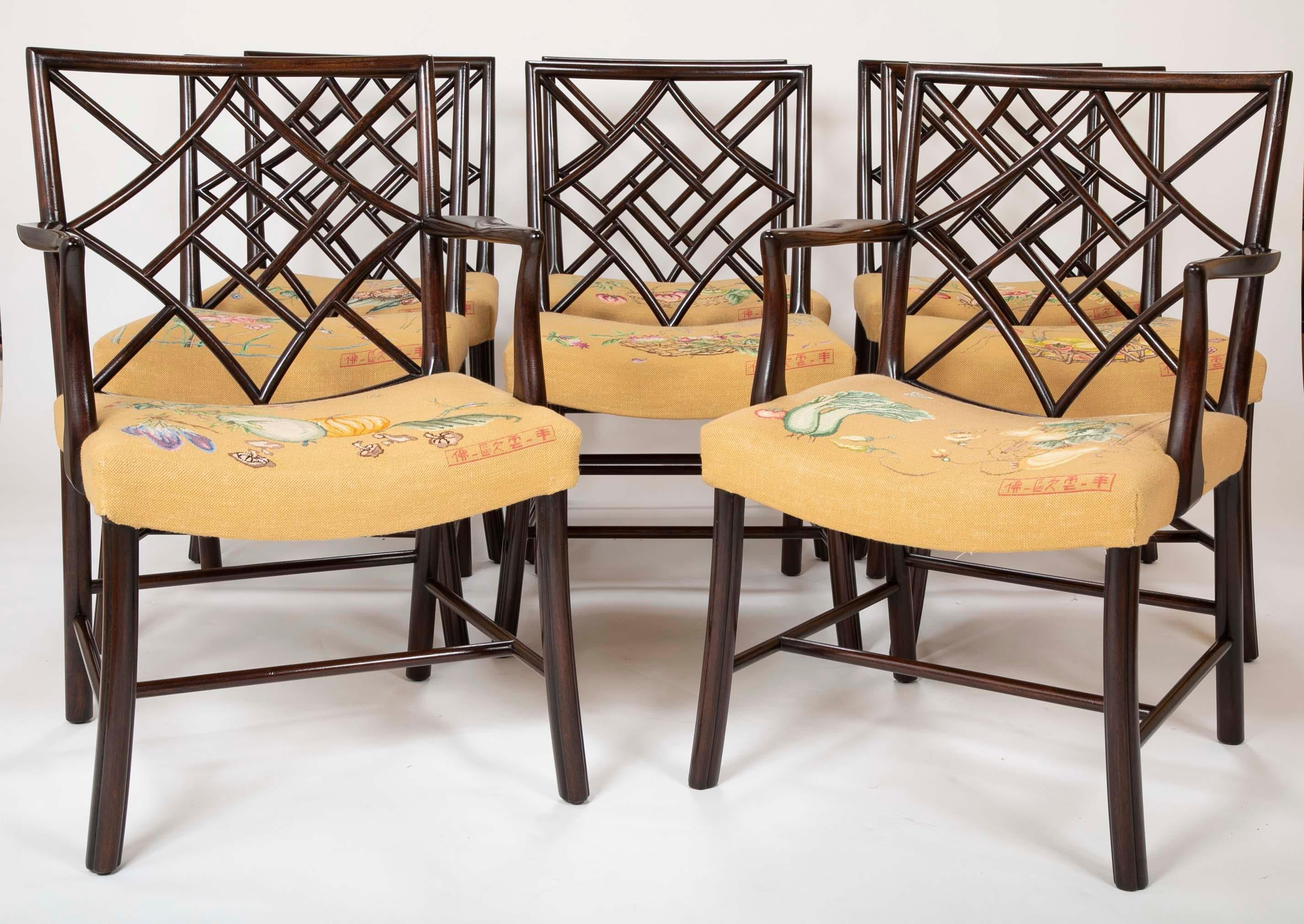 A set of 8 large Chippendale style dining chairs. Composed of 6 side chairs and two armchairs. Each chair has a different clean needlepoint design.