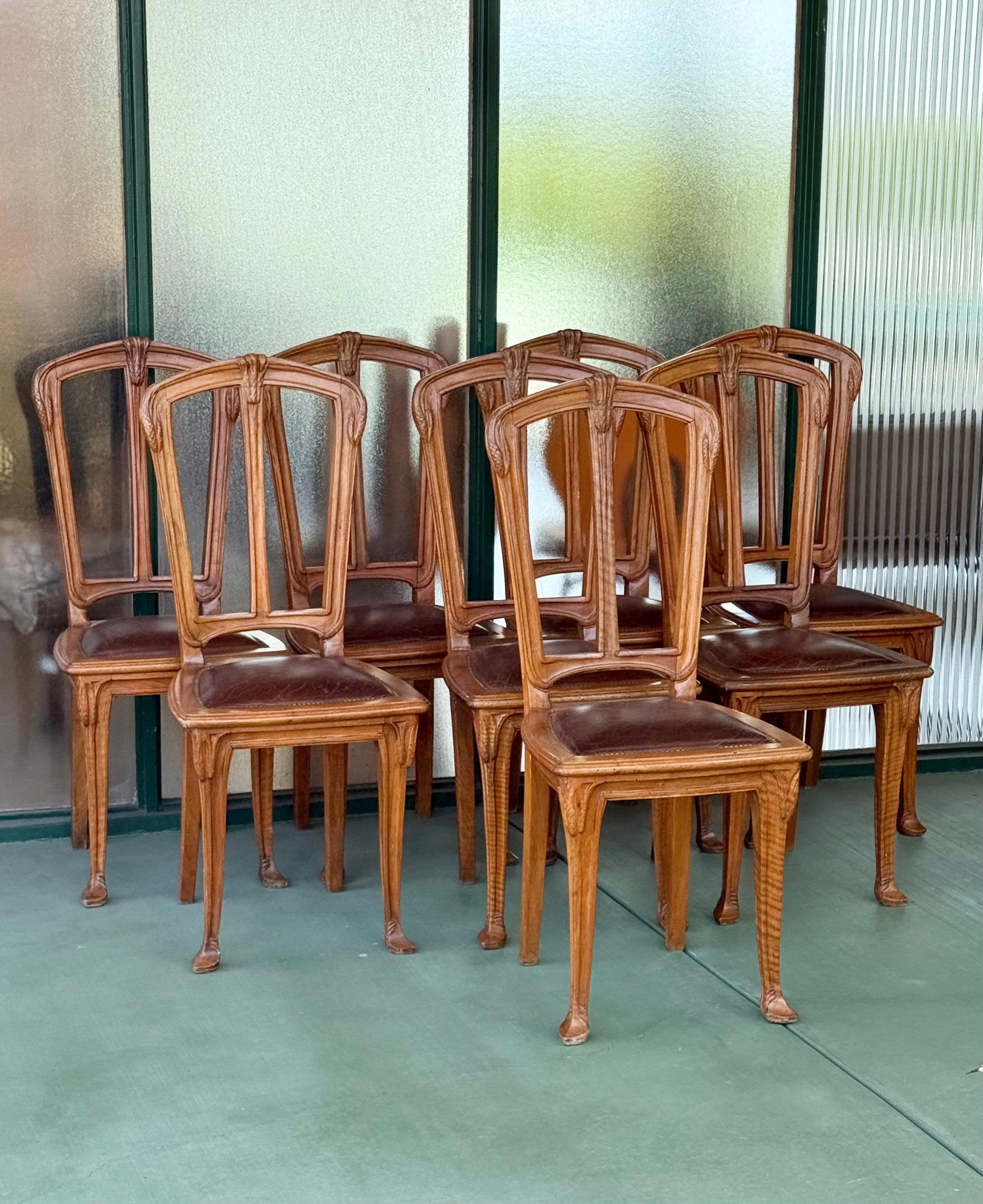 Conjunto de ocho sillas de comedor Art Nouveau muy talladas, Francia finales del siglo XIX o principios del XX. Con asientos de cuero marrón chocolate con tachuelas de latón. Espaldas, piernas y pies tallados. Impresionante y raro conjunto. 