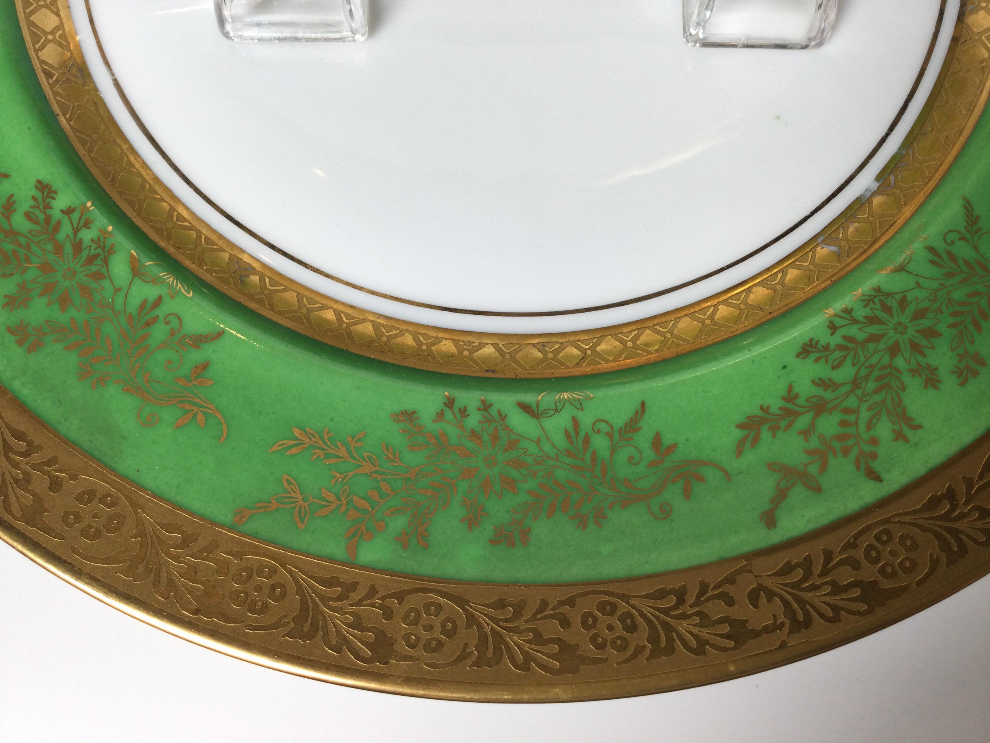Regal set of 8 gold and apple green bordered service plates. The circular gold bands with apple green background with gilt branch decoration. Porcelain, Germany, mid-20th century. Measure: 10.75 diameter.