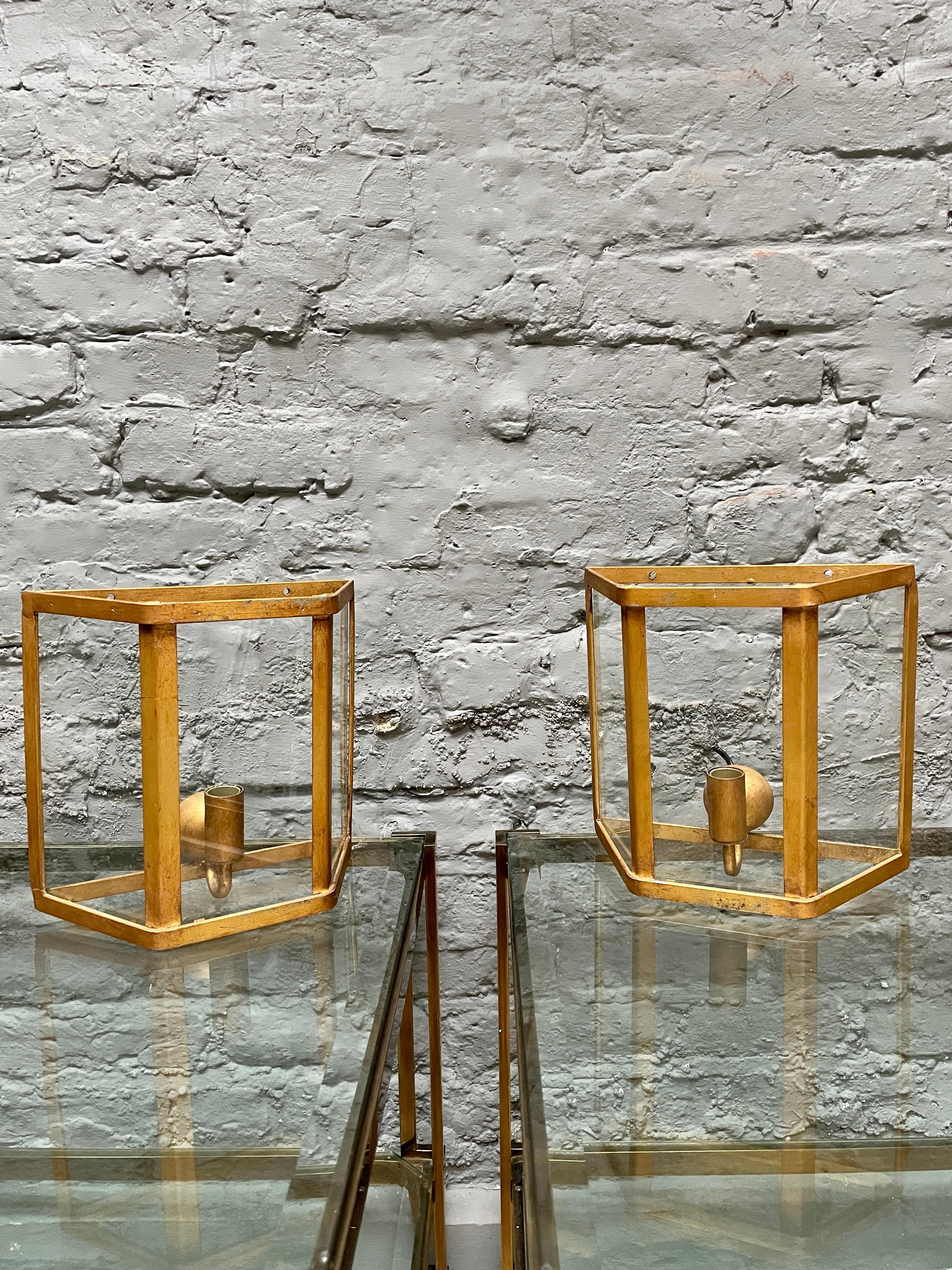 A run of 8 gold gilt iron wall lights, with 3 glass panels and open top and bottom. One light fitting within. Apparently bespoke made for an apartment in Amsterdam.
Imported from Holland.

Circa 1990.
