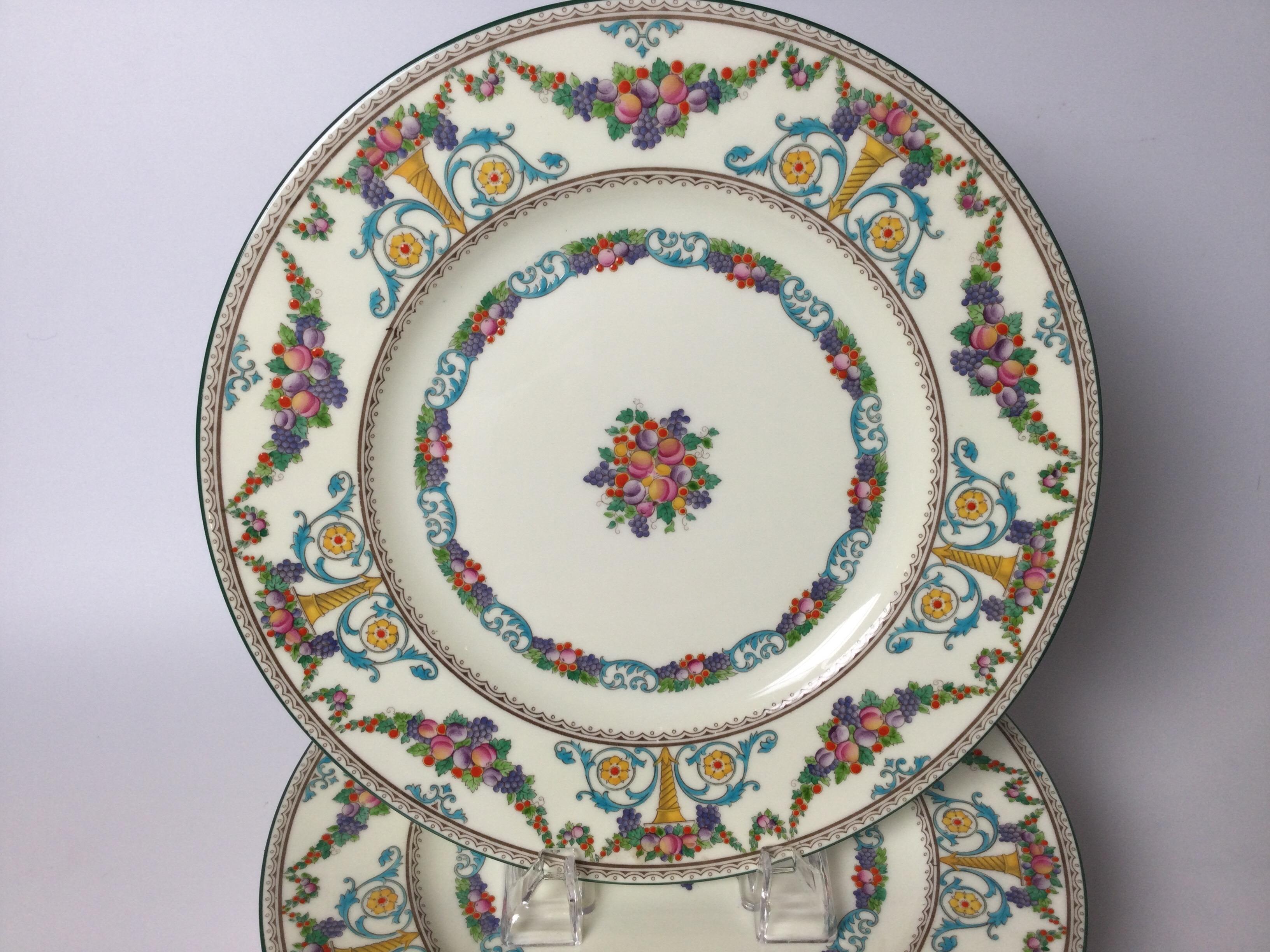 A set of 8 hand enameled service dinner plates. The vibrantly colored hand enameled and painted plates with garlands and uns of fuit a floral bouquets. England 1930s.