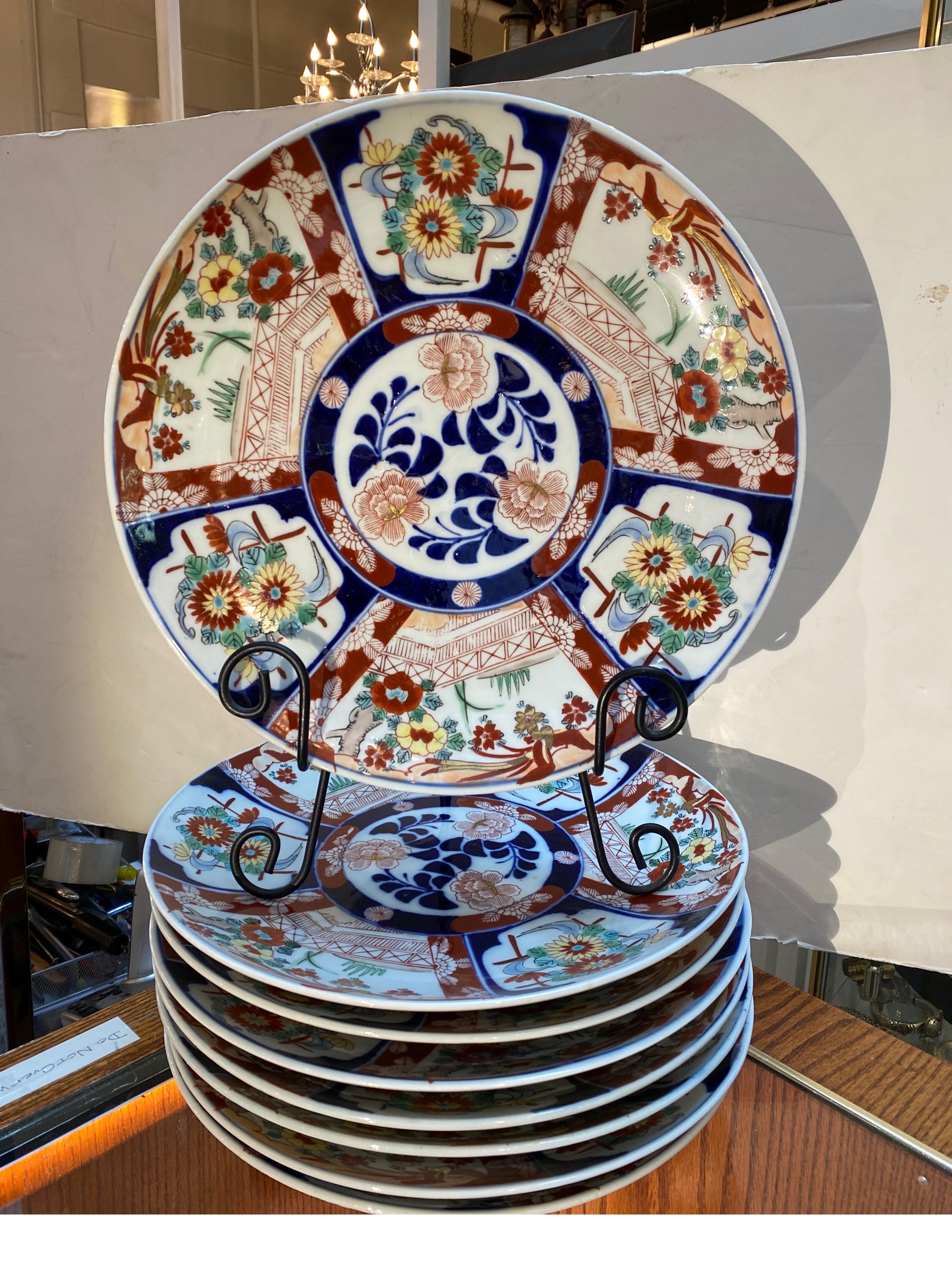 A rare set of eight classic hand painted Japanese Imari charges.  The white porcelain with traditional cobalt blue and iron red decoration, signed on the back, each 12.5 inches in diameter, will fill a cabinet beautifully. 