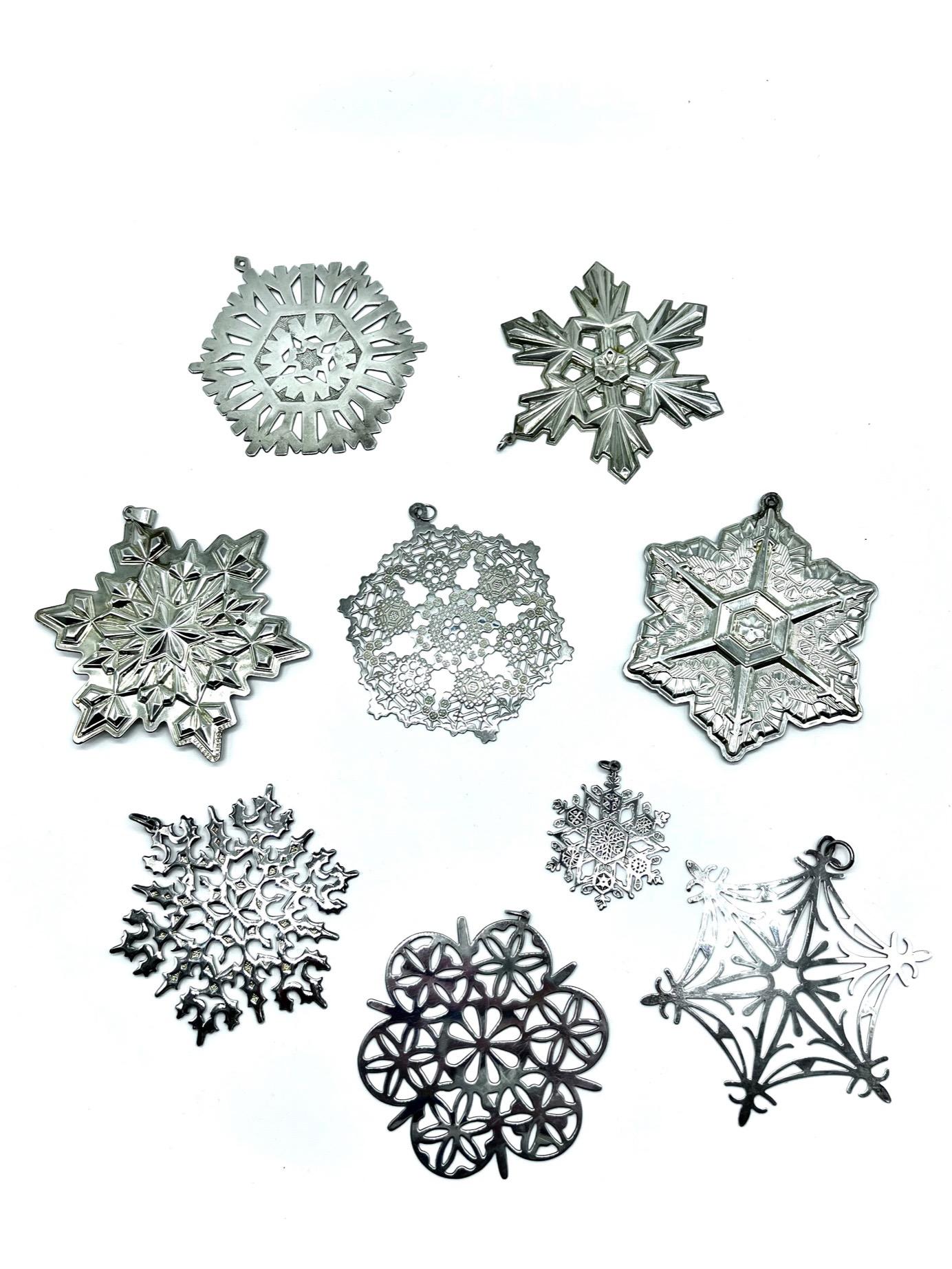 Presenting a captivating collection of nine meticulously crafted American silver snowflake ornaments, each one representing a distinct year's edition. Among them, three have been expertly created by the Gorham Manufacturing Company of Providence,