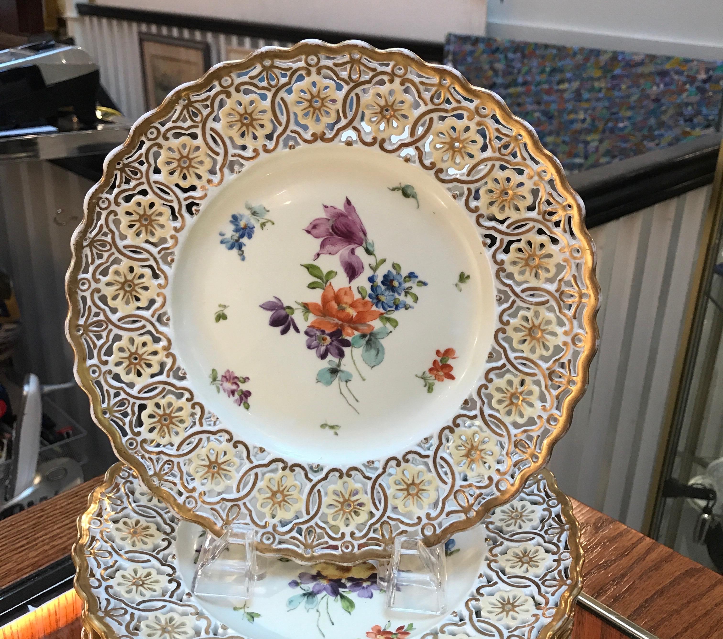 Magnifiques assiettes en porcelaine allemande peintes à la main avec une décoration florale de Dresde. Les bordures sont percées et dorées tout autour. Marqué fabriqué en Allemagne, vers 1920. Parfaites comme assiettes d'armoire ou assiettes