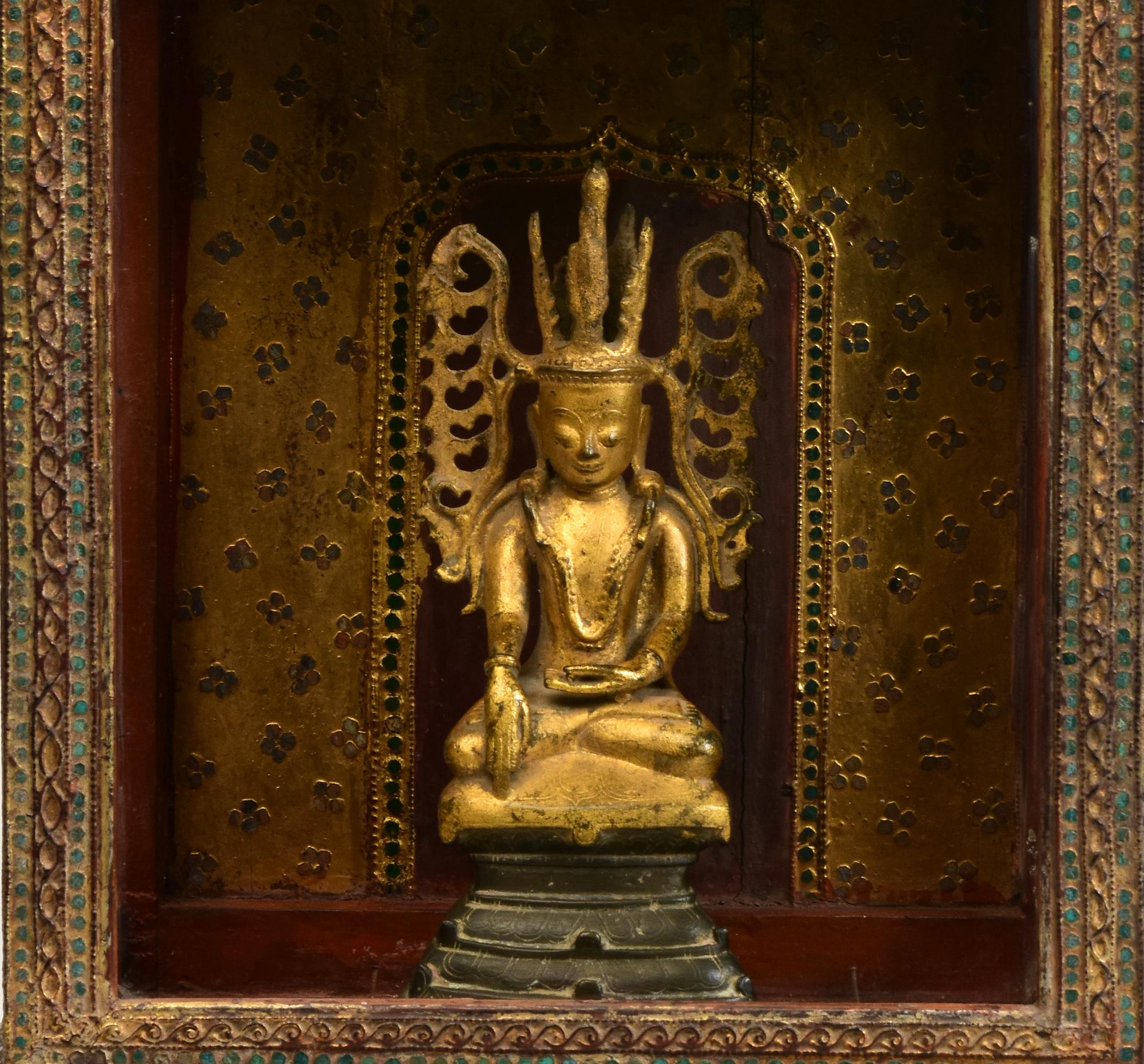 A set of Antique Burmese bronze seated crowned Buddha and wooden cabinet with gilded gold and glass.

Age of bronze Buddha: Burma, Shan period, 18th Century
Size: Height 24.6 C.M. / Width 11 C.M.

Age of wooden cabinet: Burma, Mandalay period, 19th